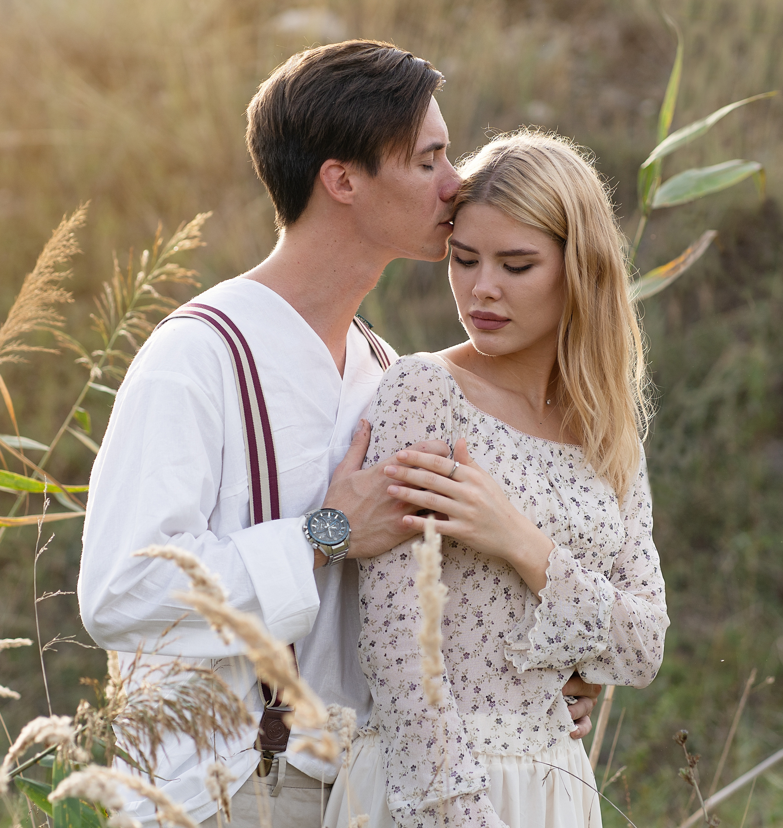 Портрет влюбленных. Он слегка обнимает девушку со спины, целует её волосы 