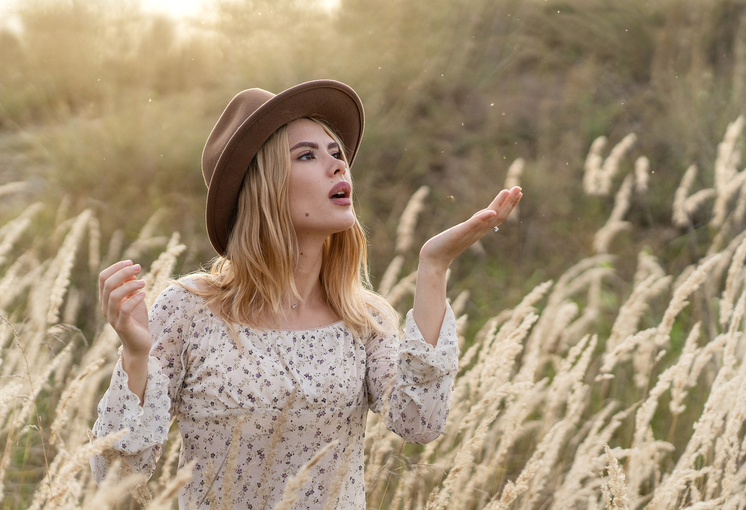 Девушка сдувает солнечную пыль с ладони.