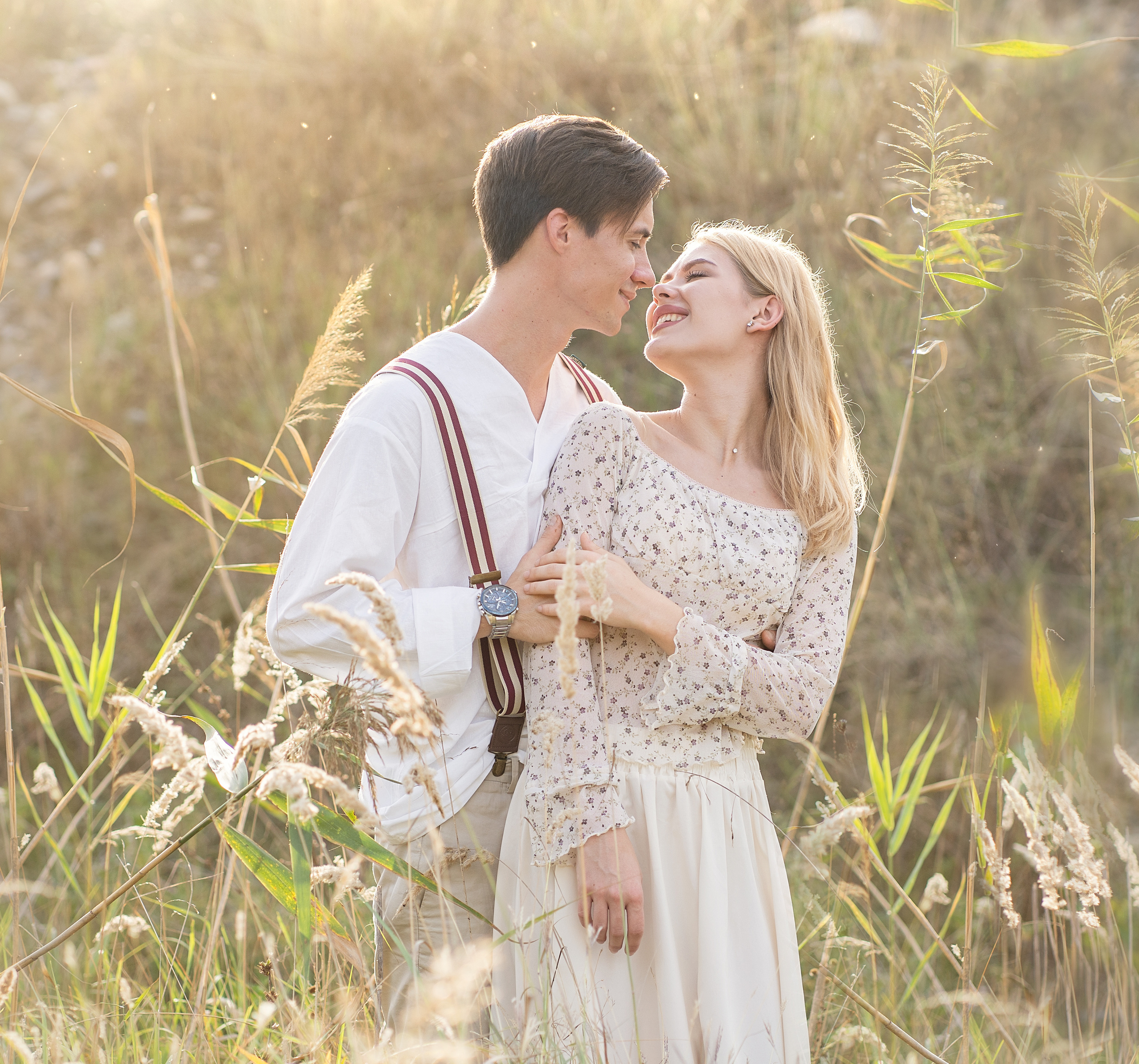 Влюбленные милуются в поле. Яркий солнечный день.