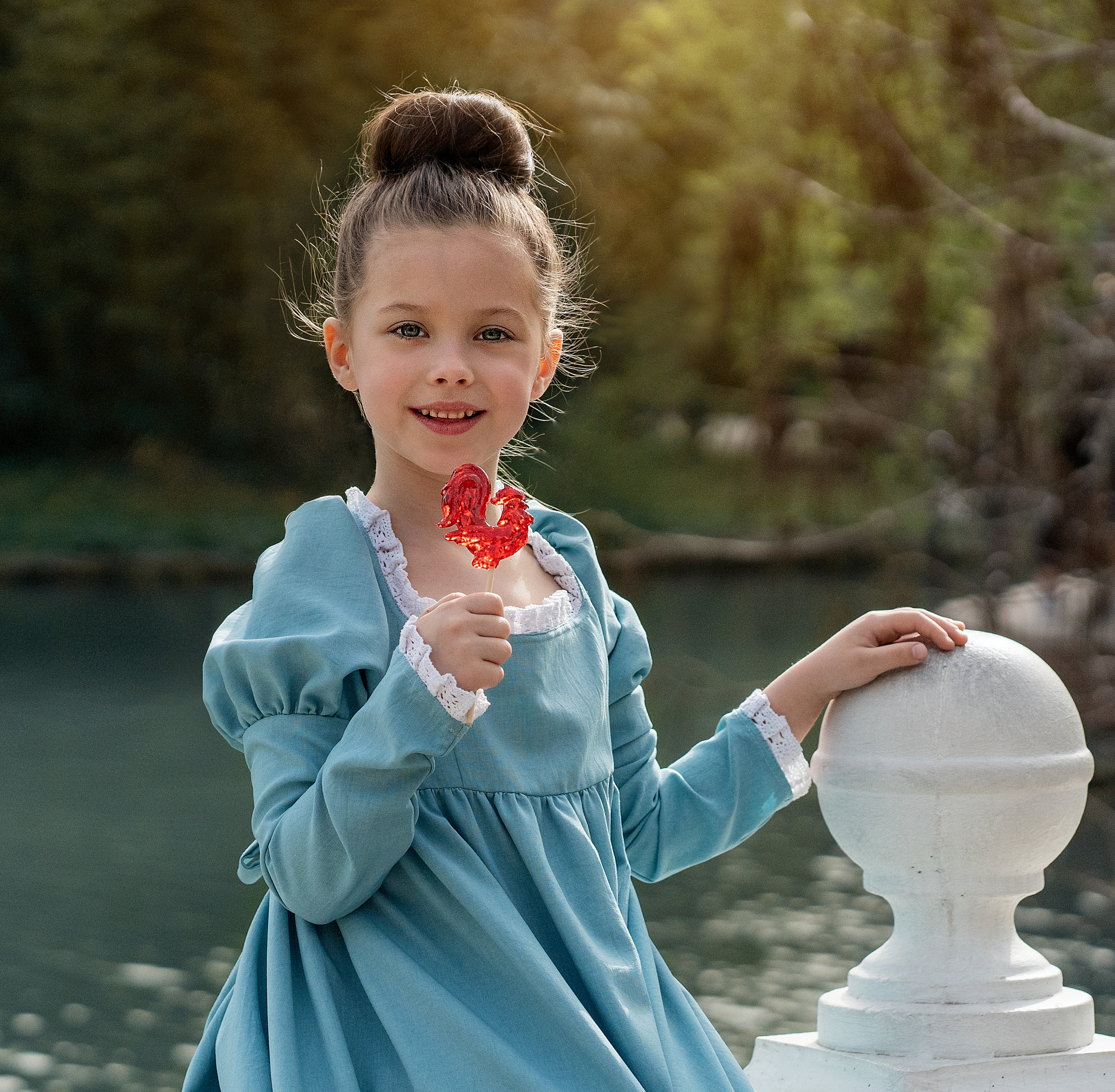 Девочка и сладкий петушок на палочке 