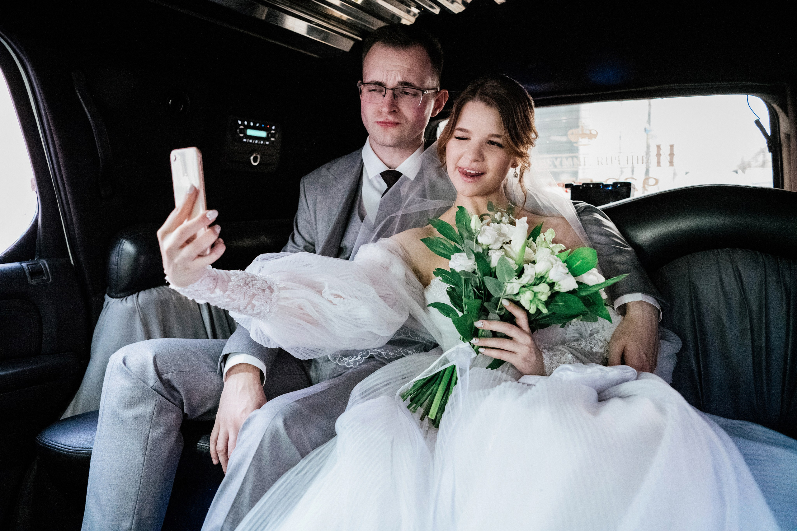 Селфи жениха и невесты в автомобиле — фото в движении