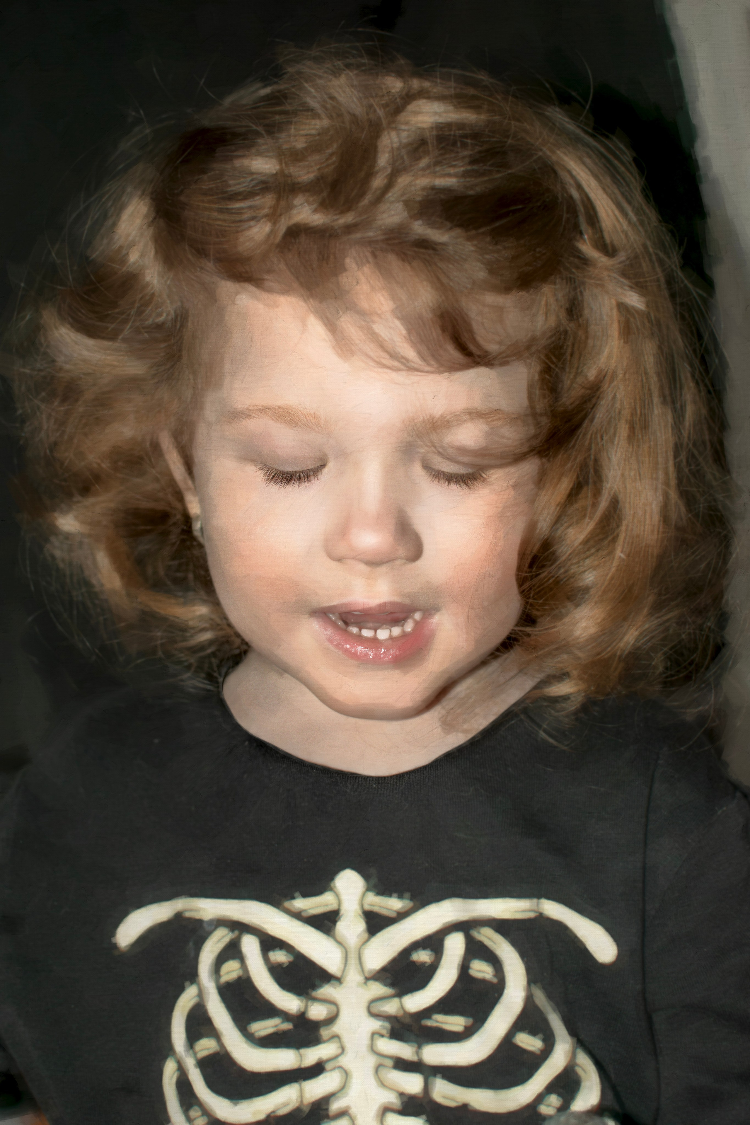 Кучерявая девочка с русыми волосами опустила глаза вниз и смеется