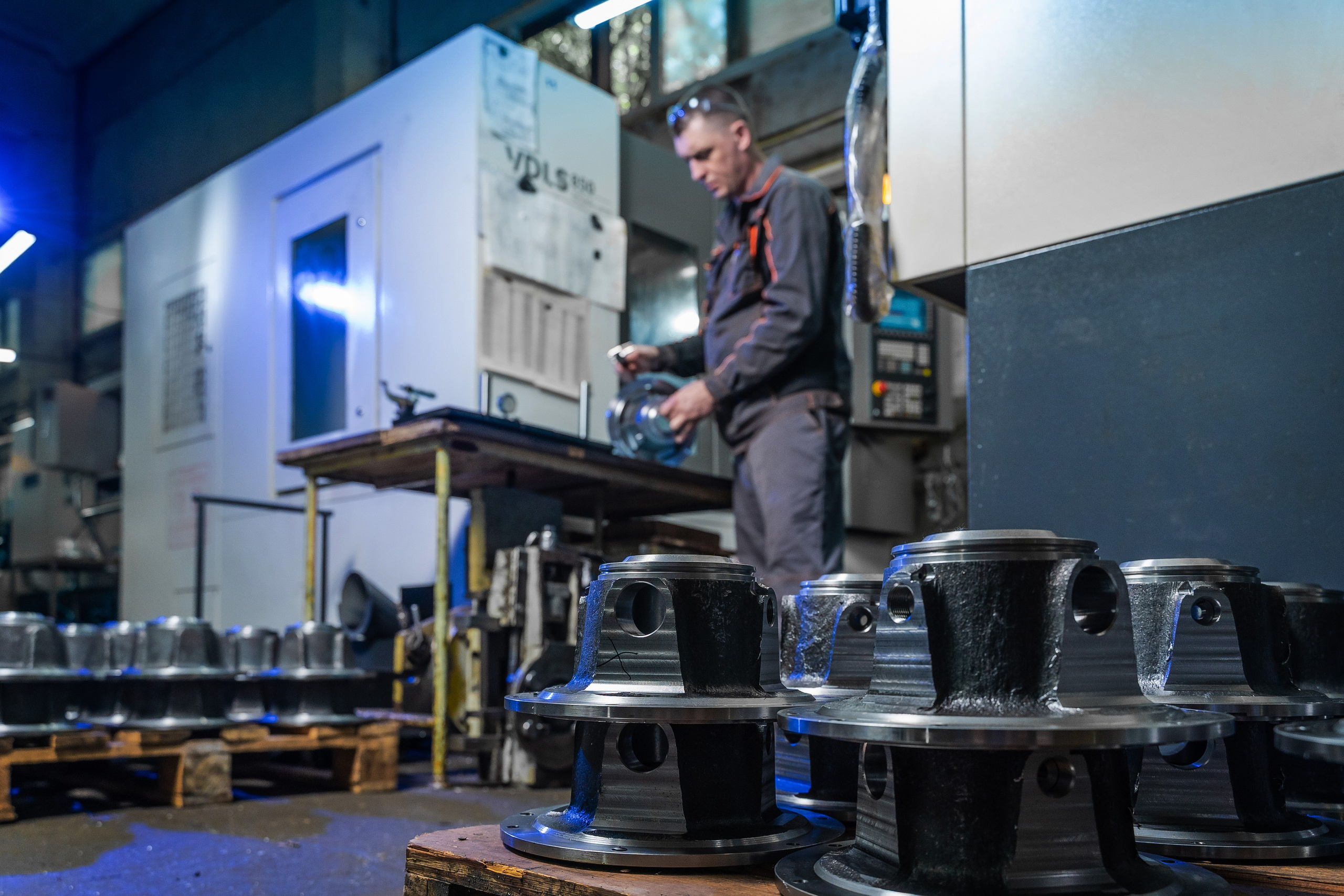 Токарь выполняет финишную обработку поверхности металлической детали