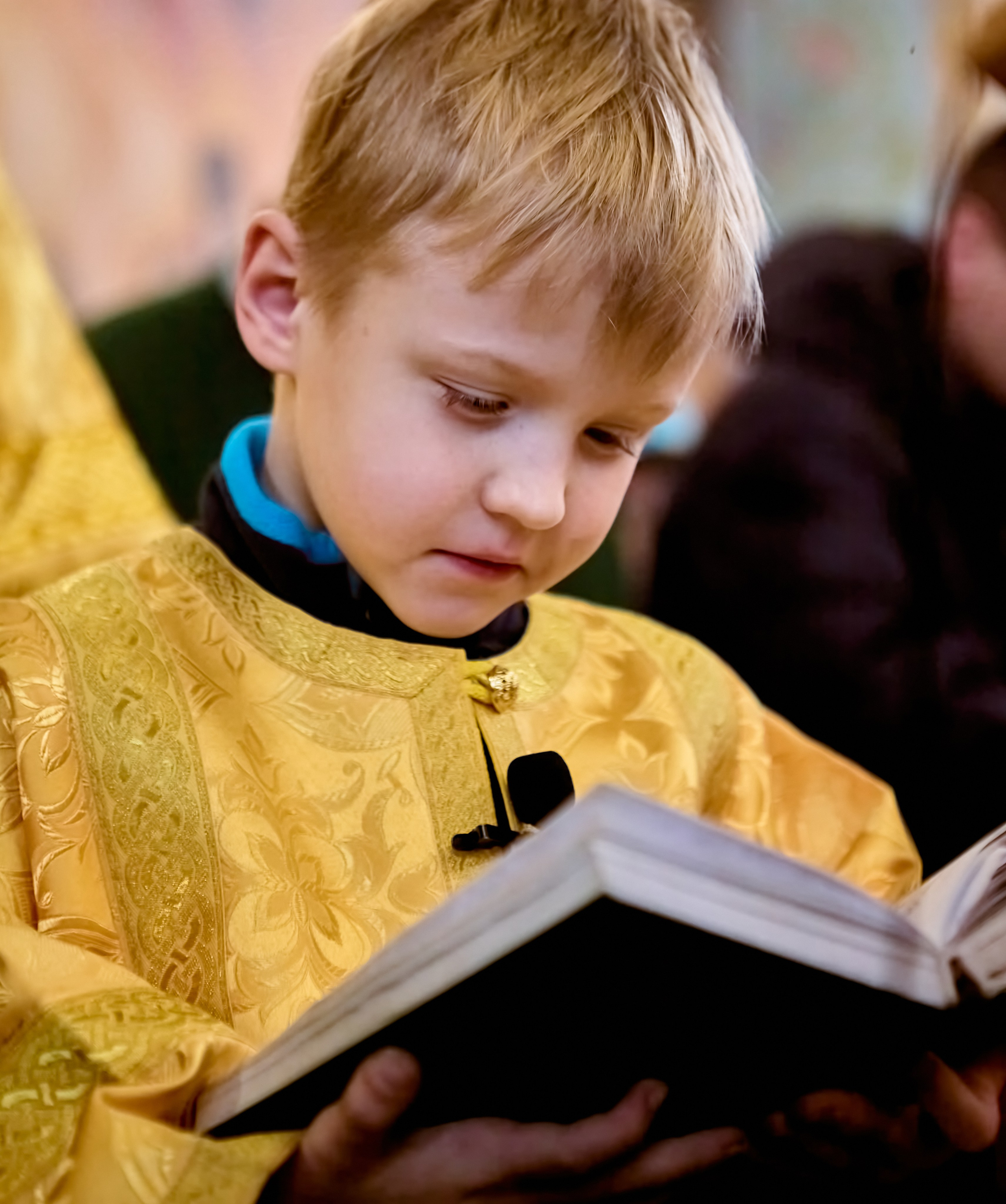 Мальчик 5-6 лет в желтом стихаре читает Апостола на водо-Святном молебне