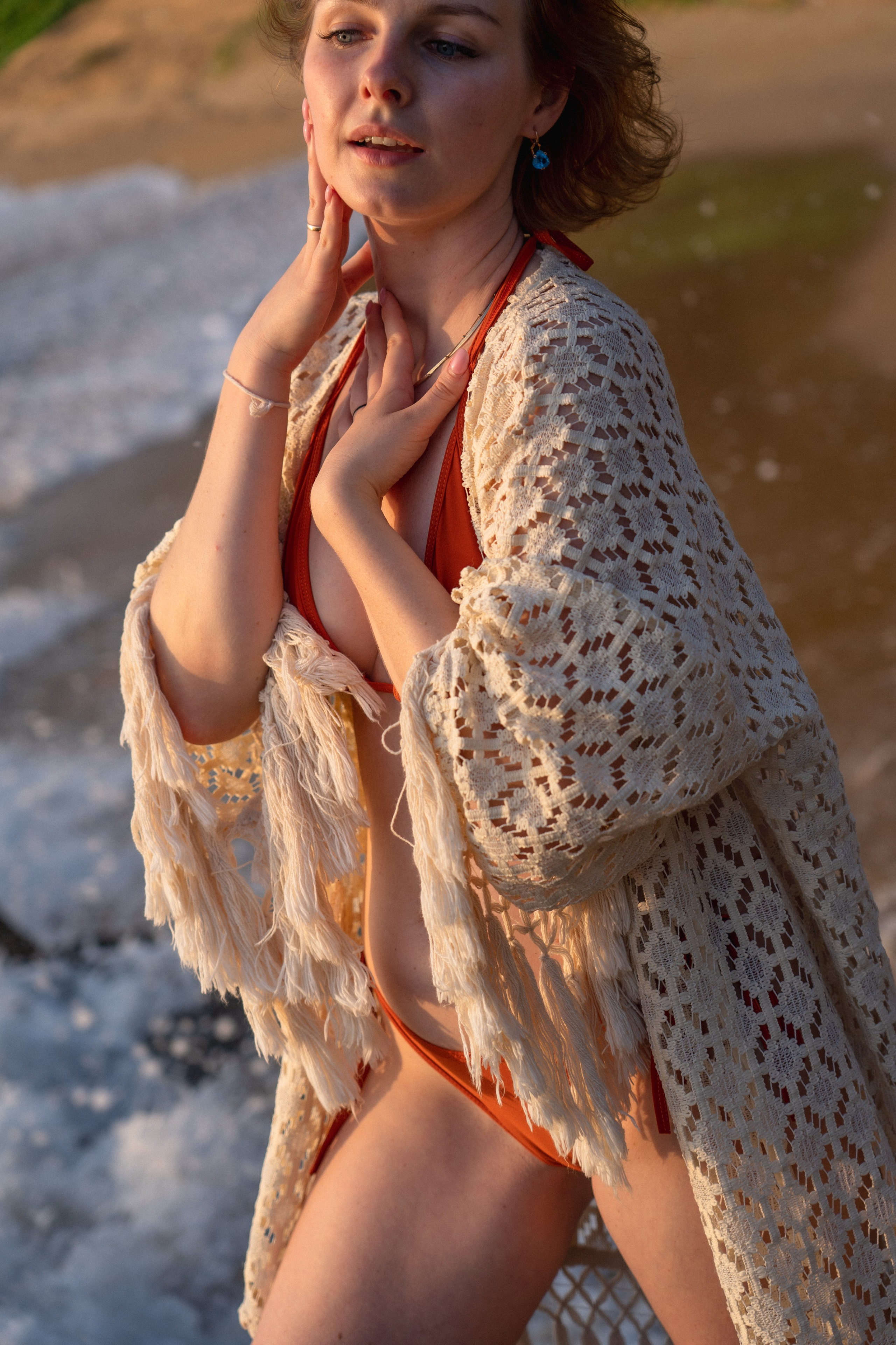 a girl in a red swimsuit admiring the sunset by the ocean