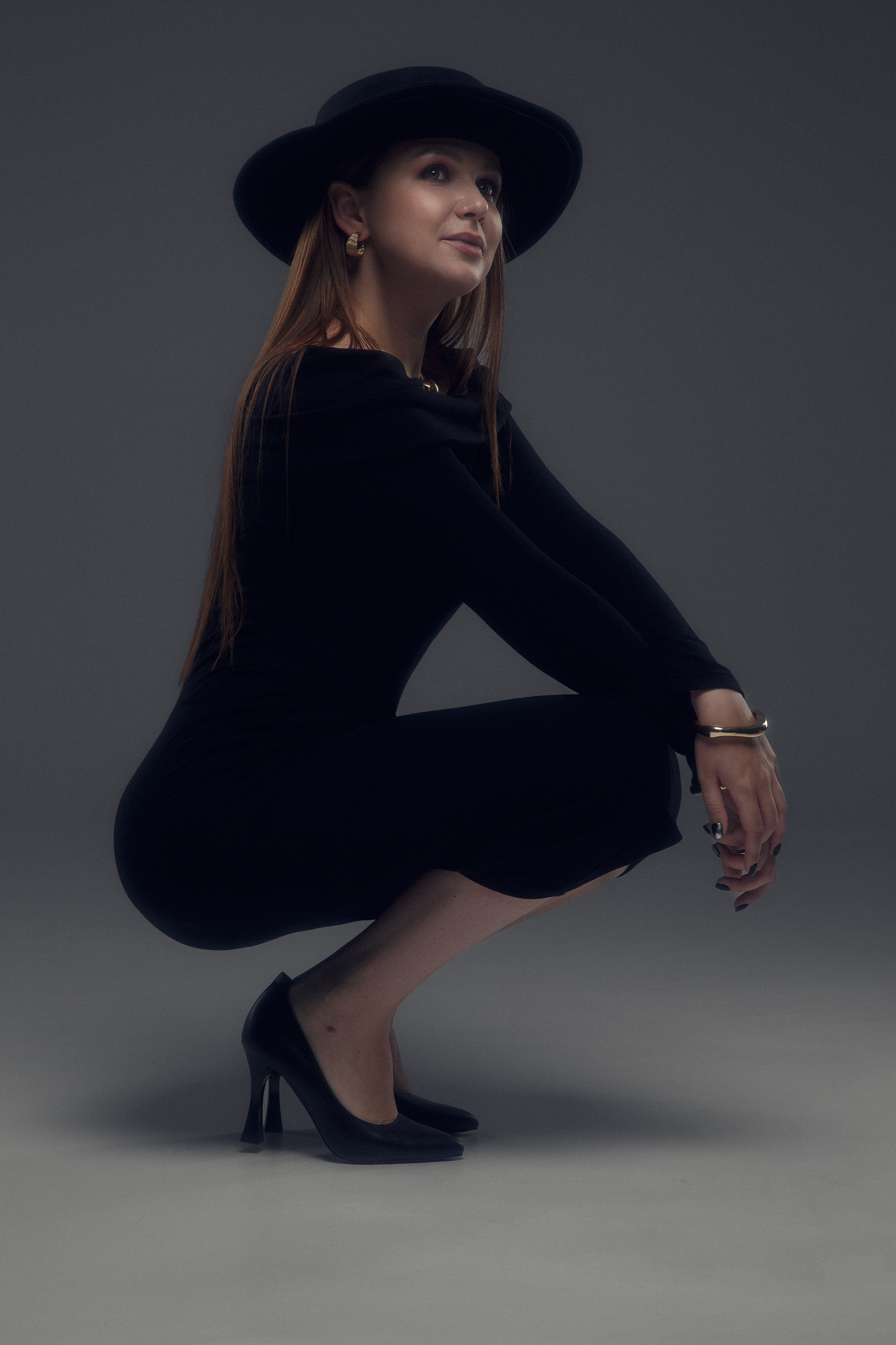 Студийный портрет женщины в элегантном черном платье.