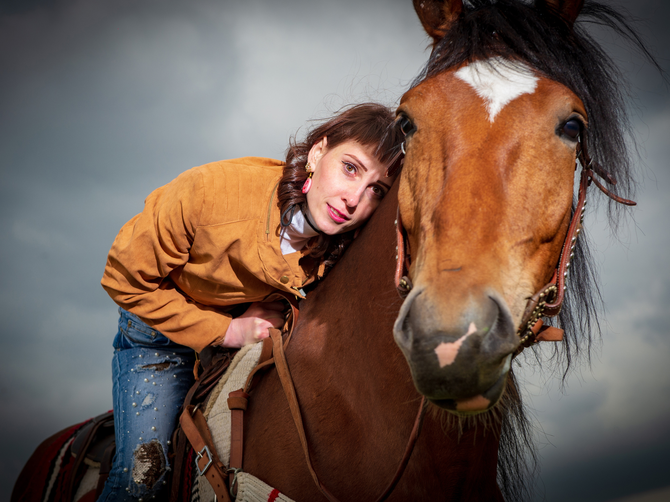 крупный портрет рыжего коня с сидящей верхом девушкой которая склонилась ему на шею 