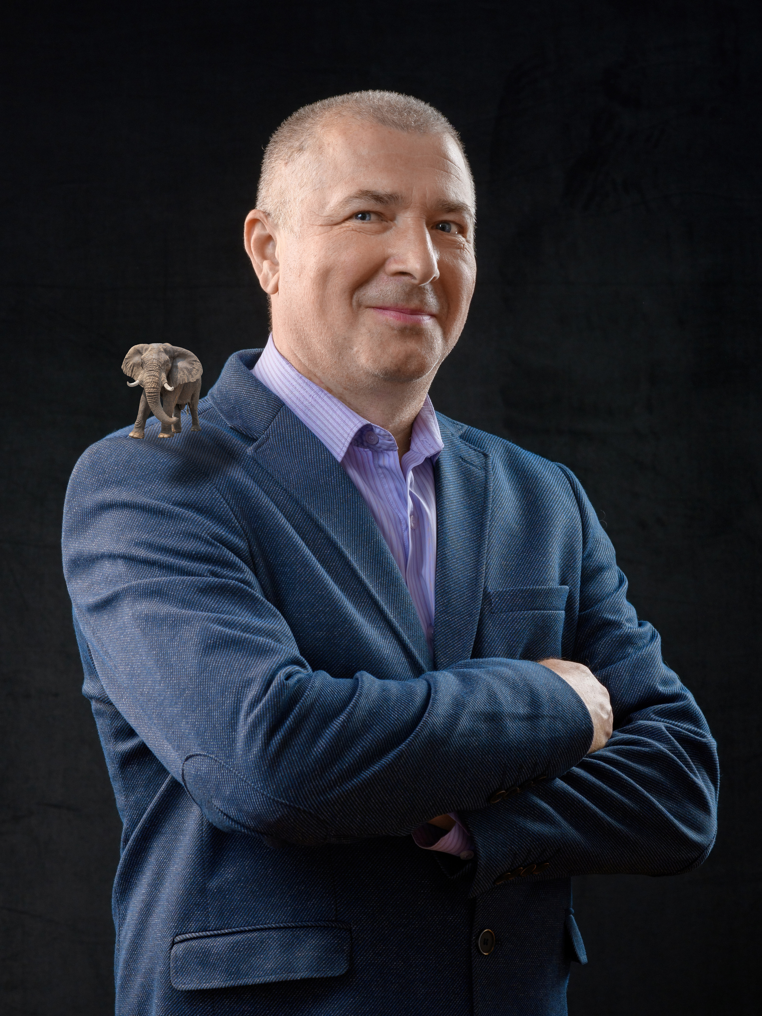 Портрет улыбающегося мужчины с маленьким слоником на плече 