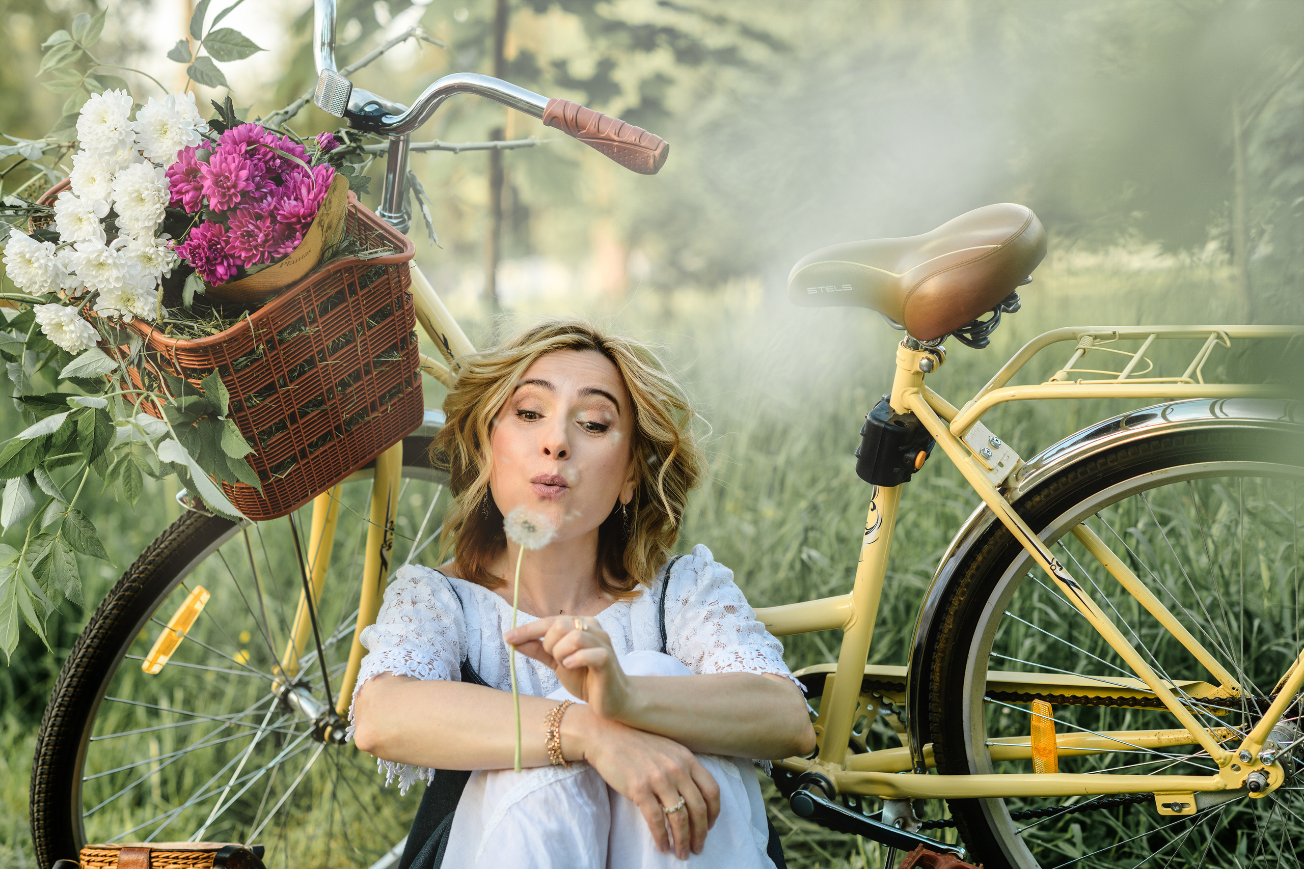 парк, девушка сидит облокотившись на стоящий за спиной велосипед  с корзиной цветов