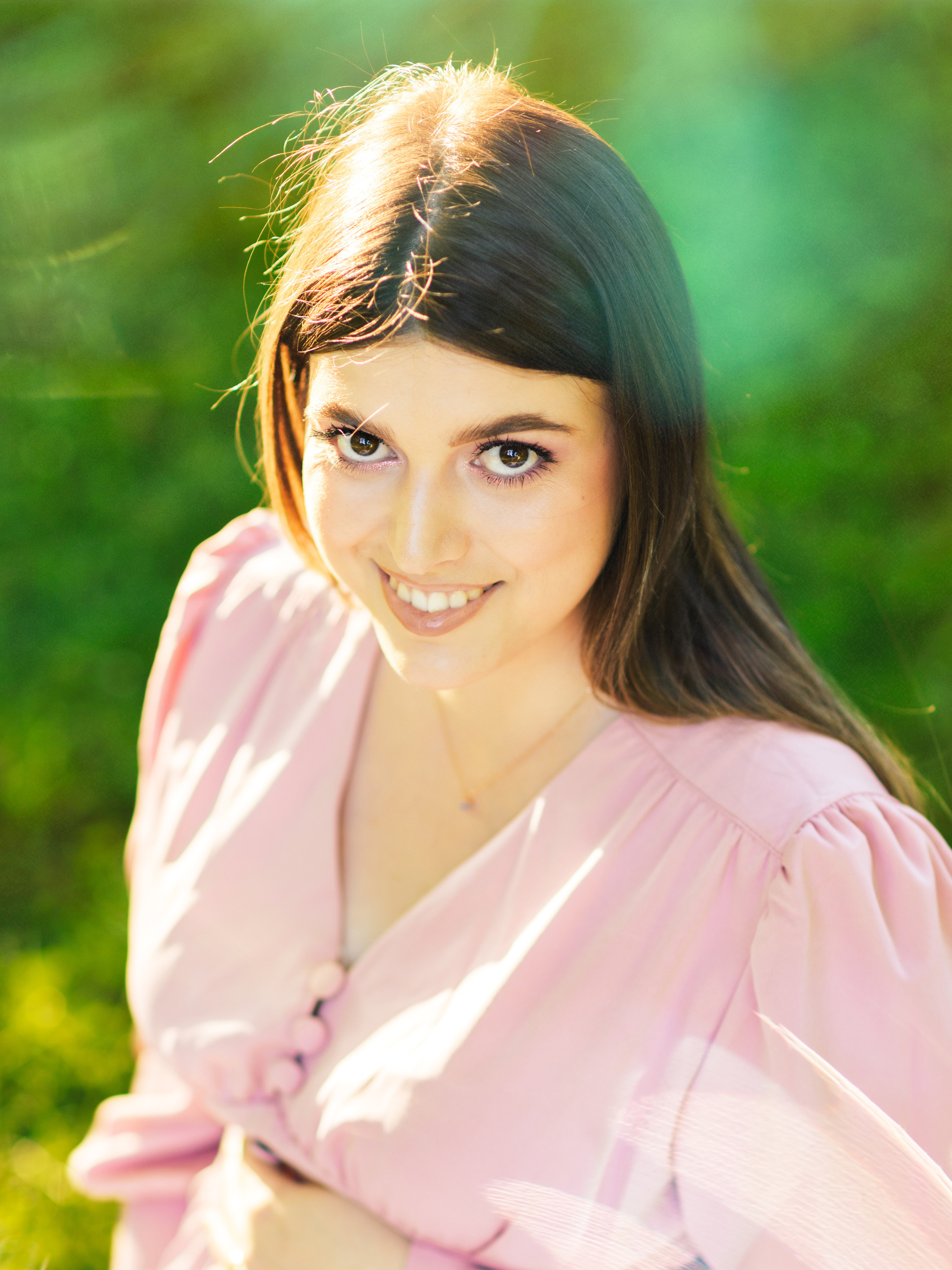 портрет в парке девушка в розовом платье улыбается фотографу