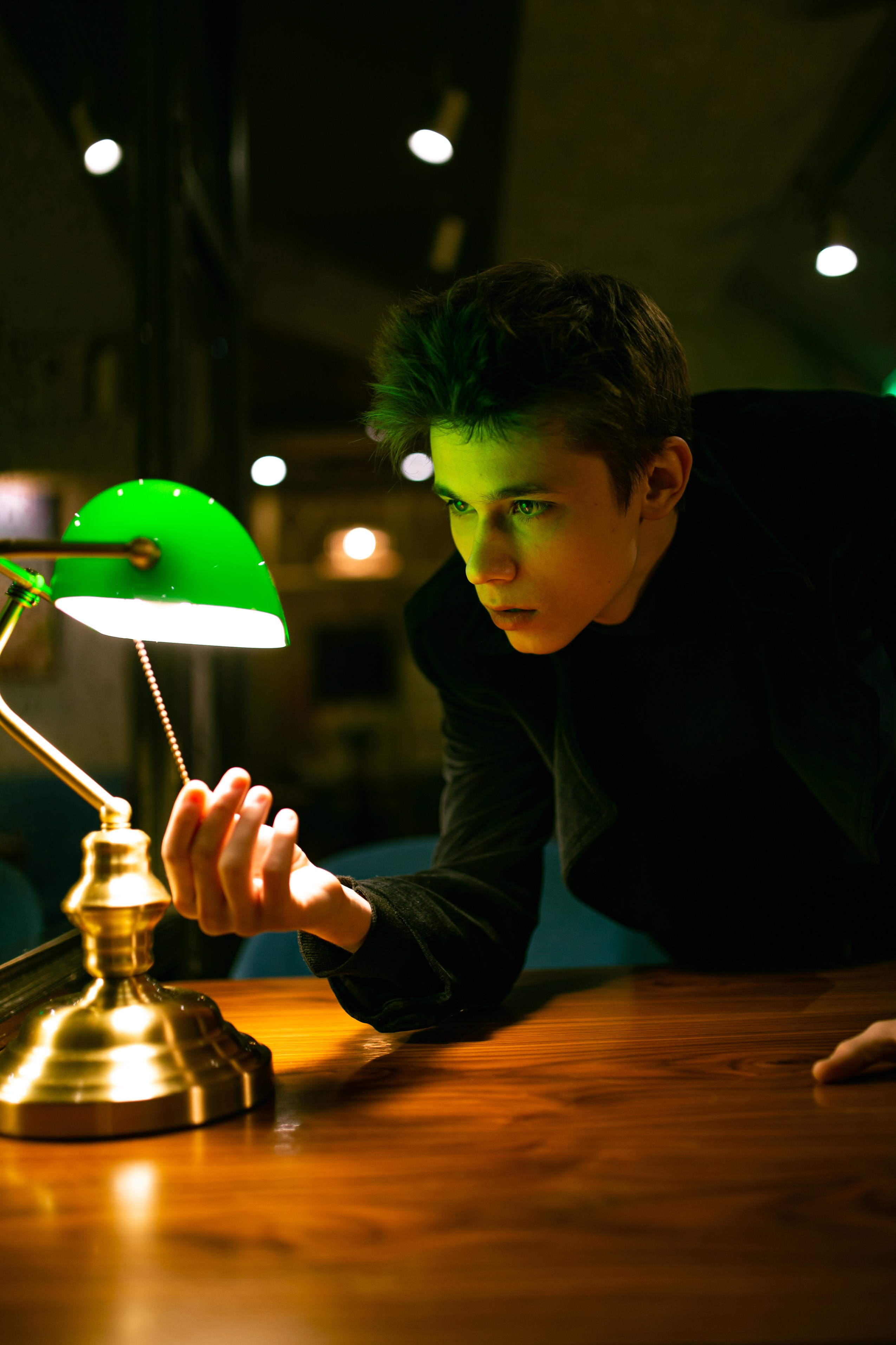 Саша Алексеев актер включил лампу в темной комнате.