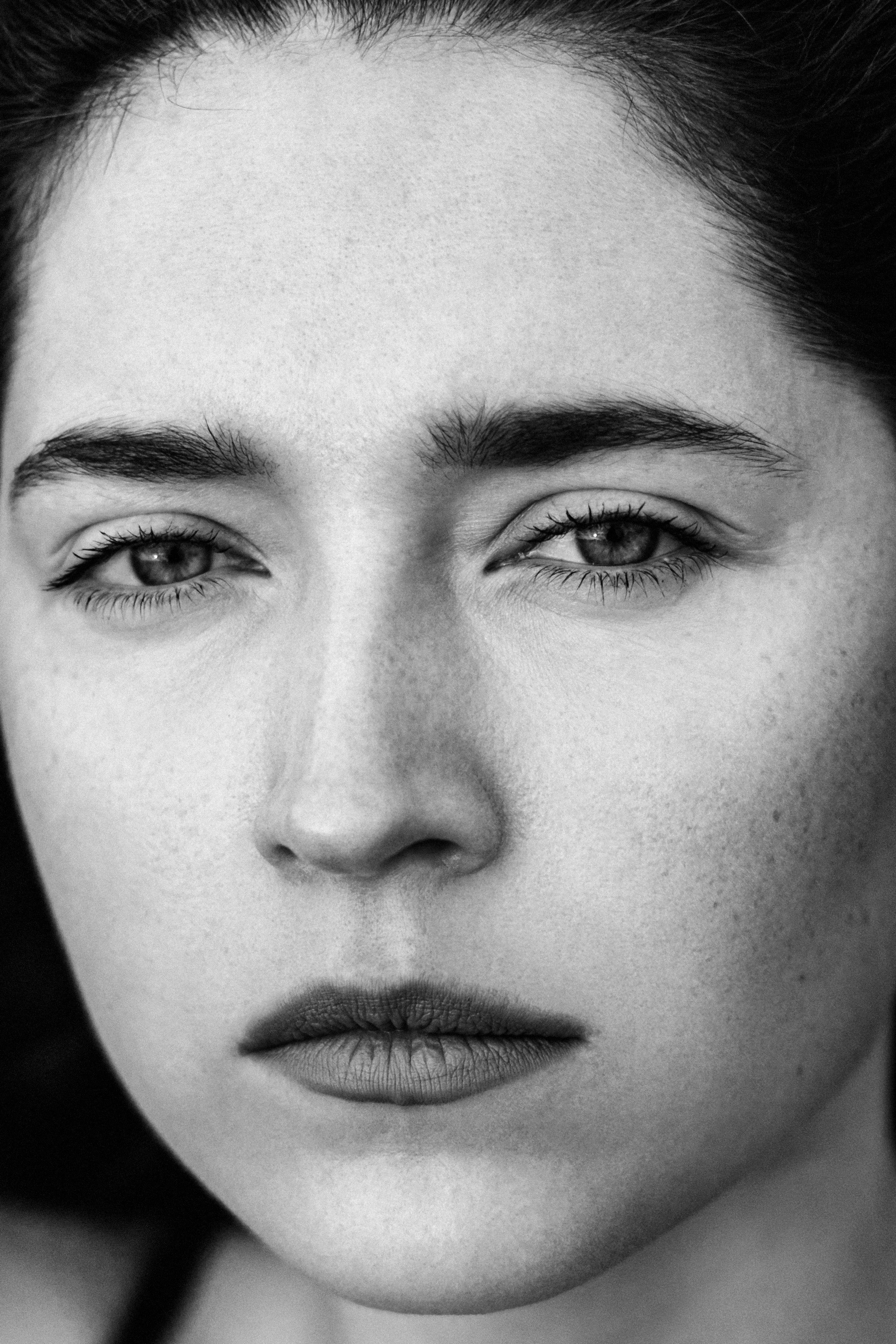 красивая девушка со строгим и пронзительным взглядом смотрит в камеру