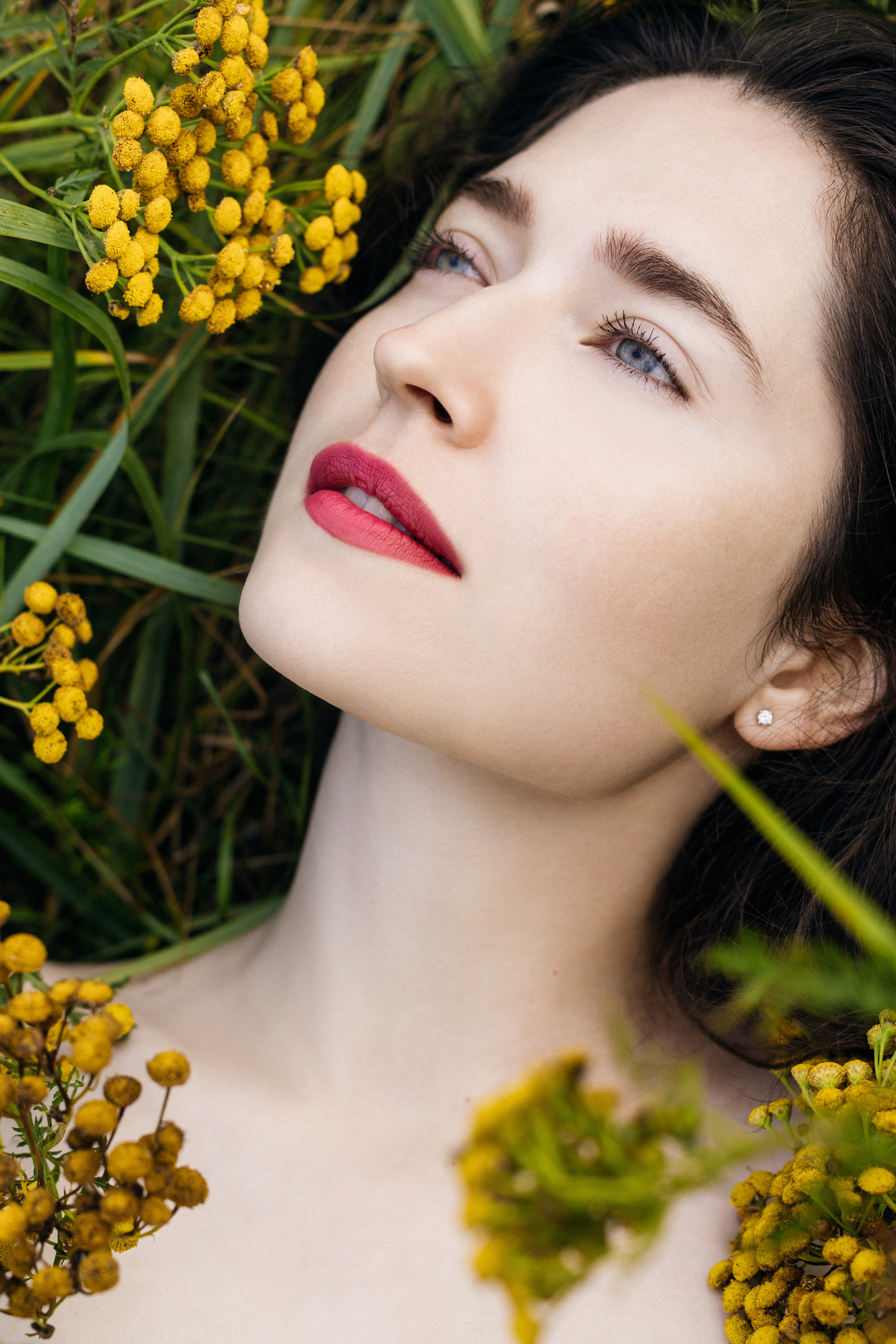 красивая девушка с чистейшей и нежной белой кожей лежащая в траве среди желтых цветов 