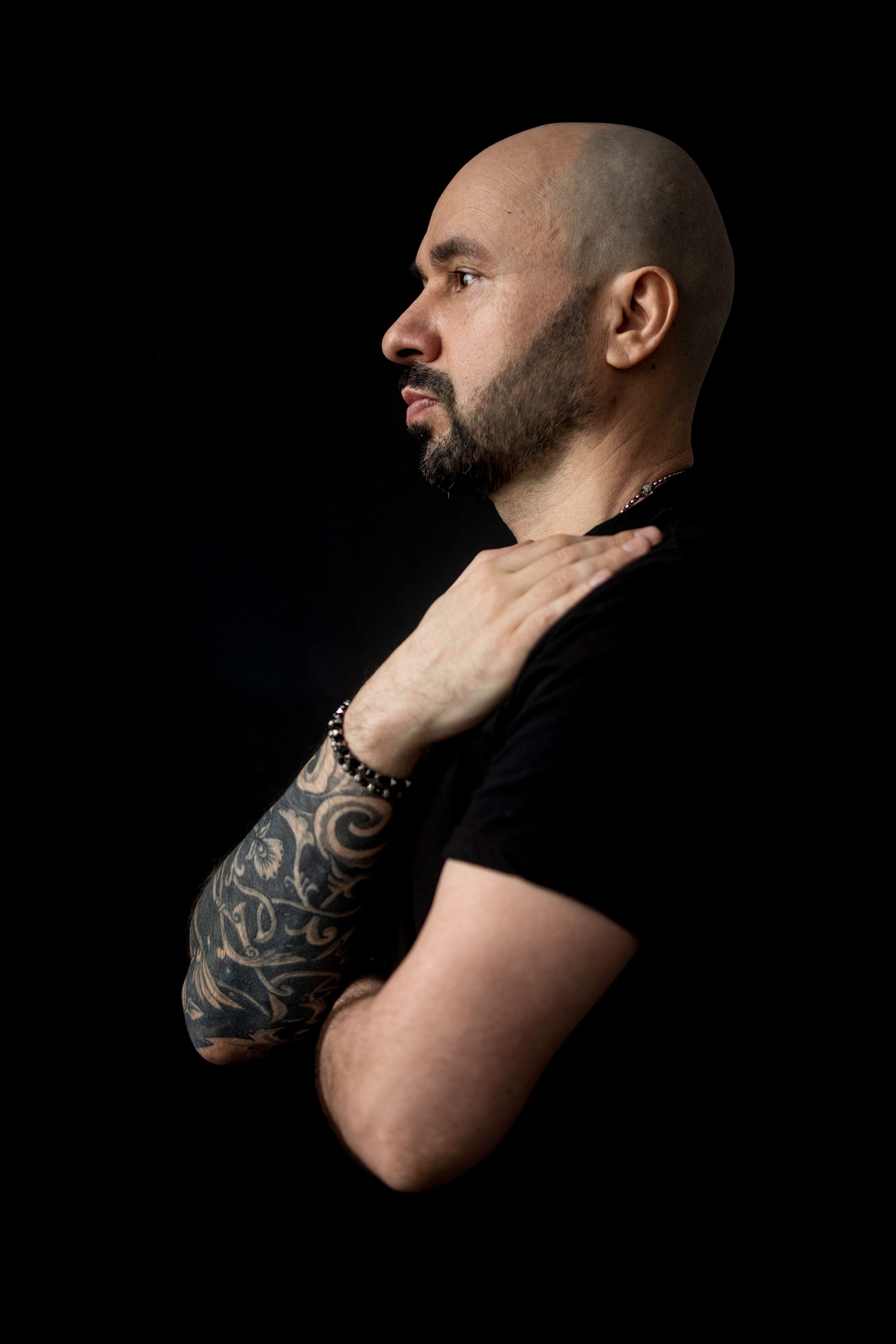 портрет мужчины с татуировками на руках
