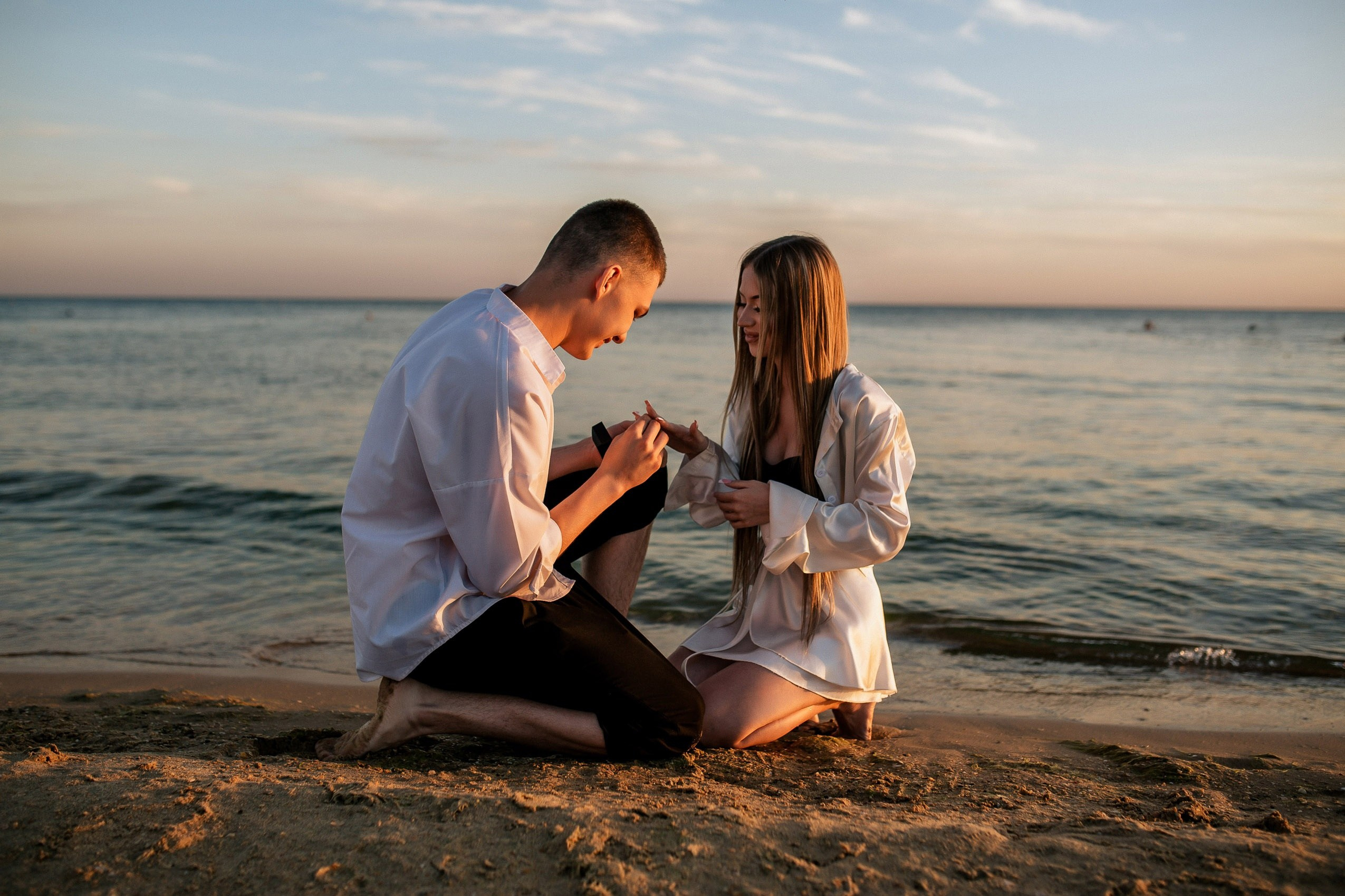 Фотография запечатлила момент предложения руки и сердца на берегу моря.