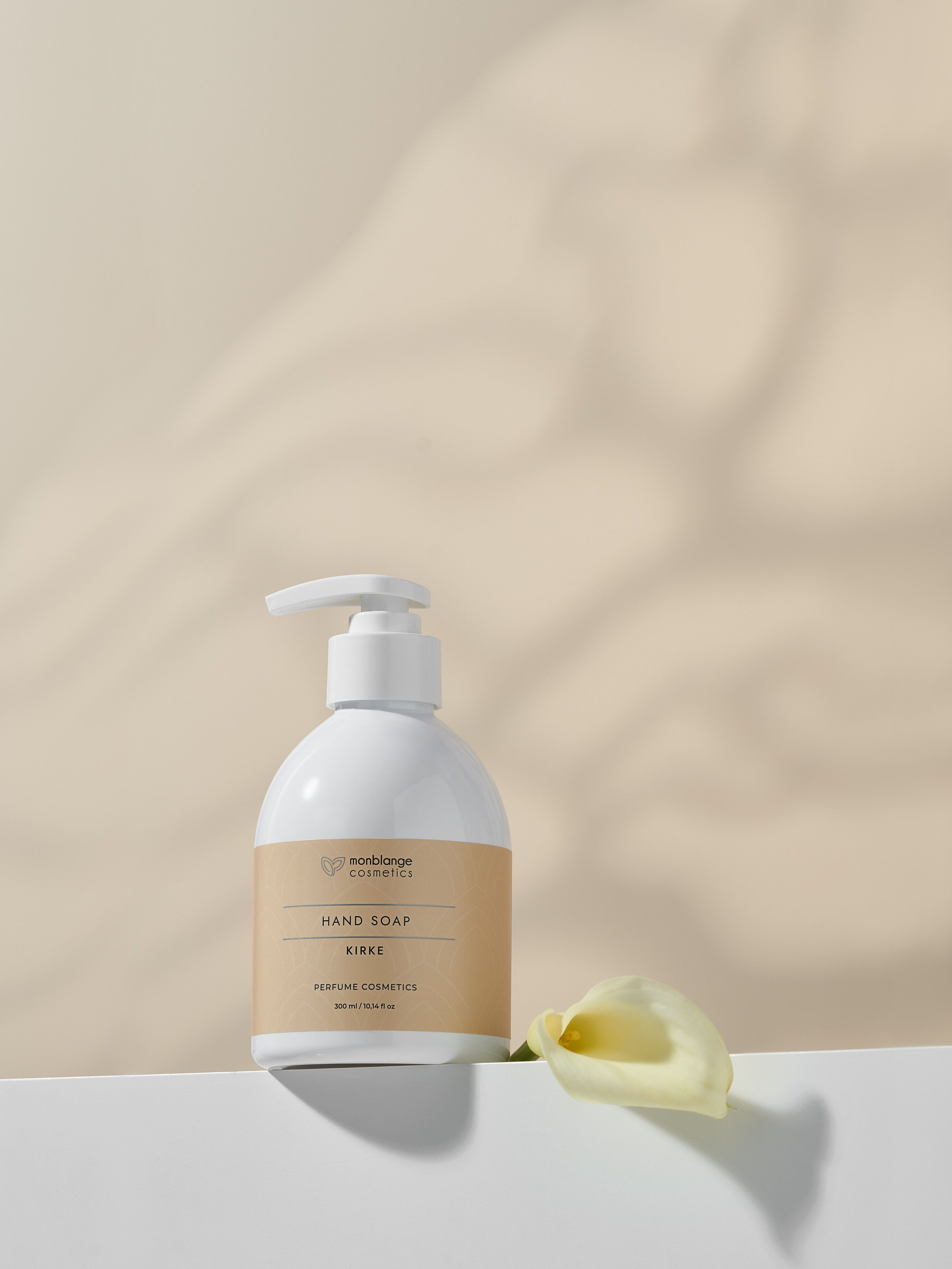 Мыло для рук стоит на белом подиуме рядом с белым цветком