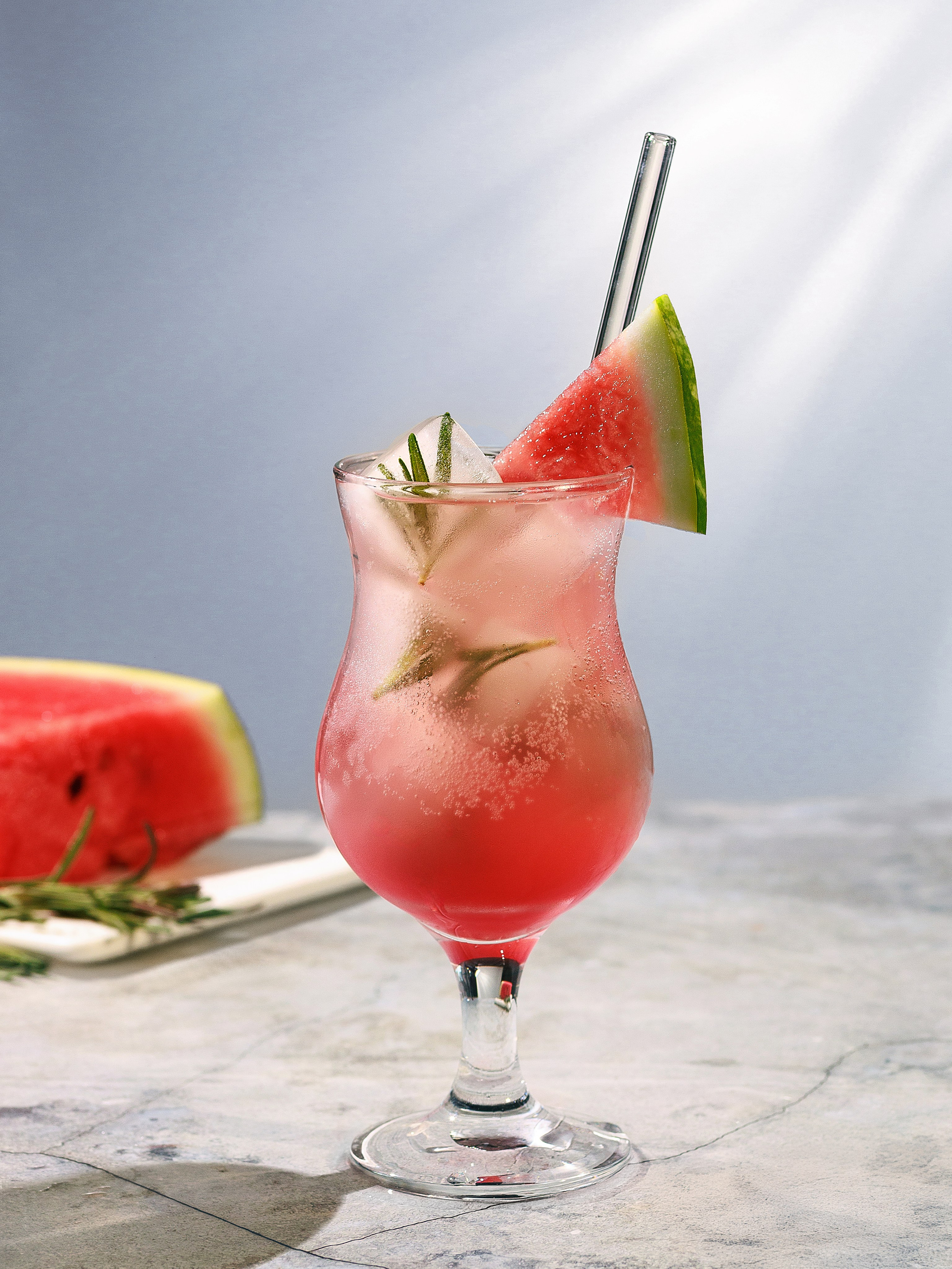 арбузный коктейль со льдом и розмарином в лучах солнца. Фудфото арбузного коктейля