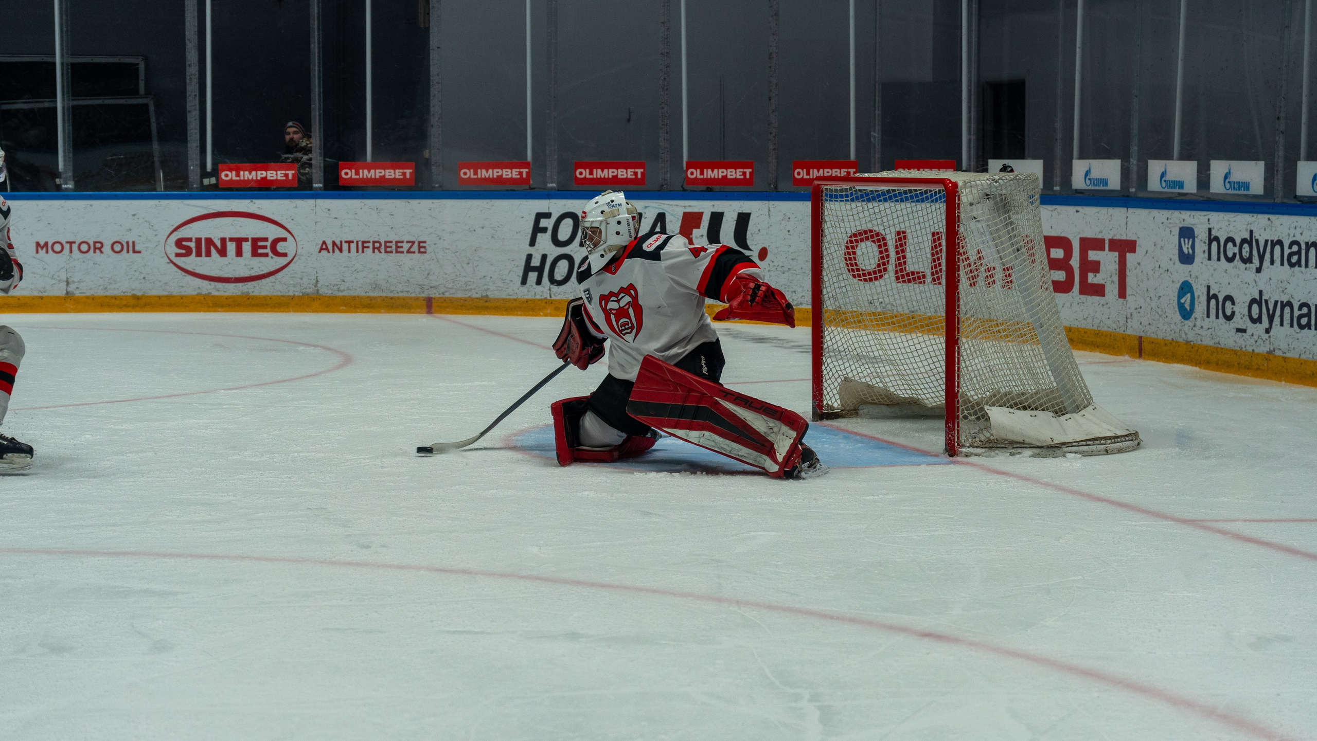 Вратарь «Молота» спасает ворота в напряжённом моменте матча с «Динамо» в Санкт-Петербурге. Спортивная фотосъёмка, репортажный стиль.