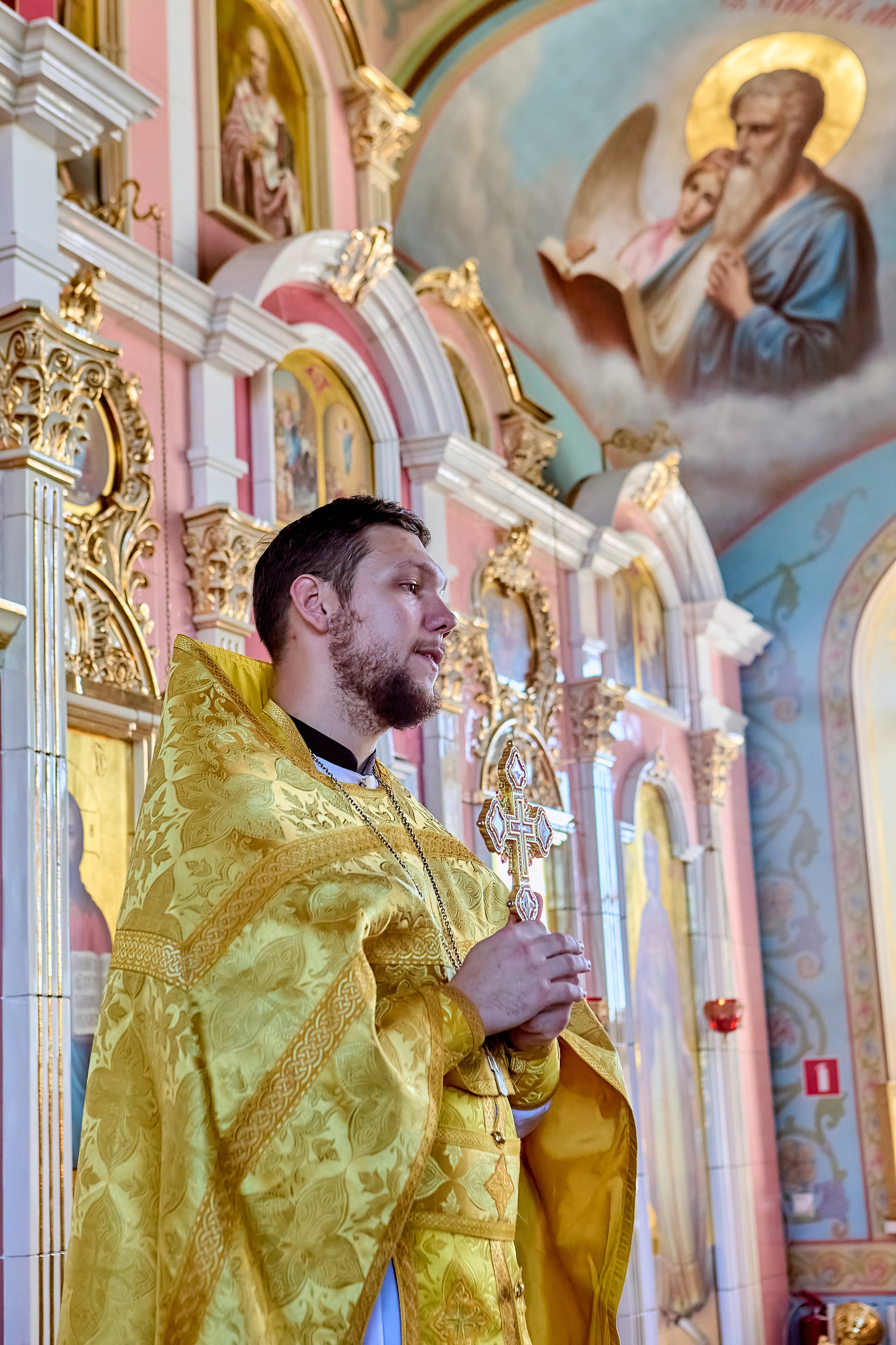 Священник с крестом на амвоне говорит проповедь о Христе Иисусе