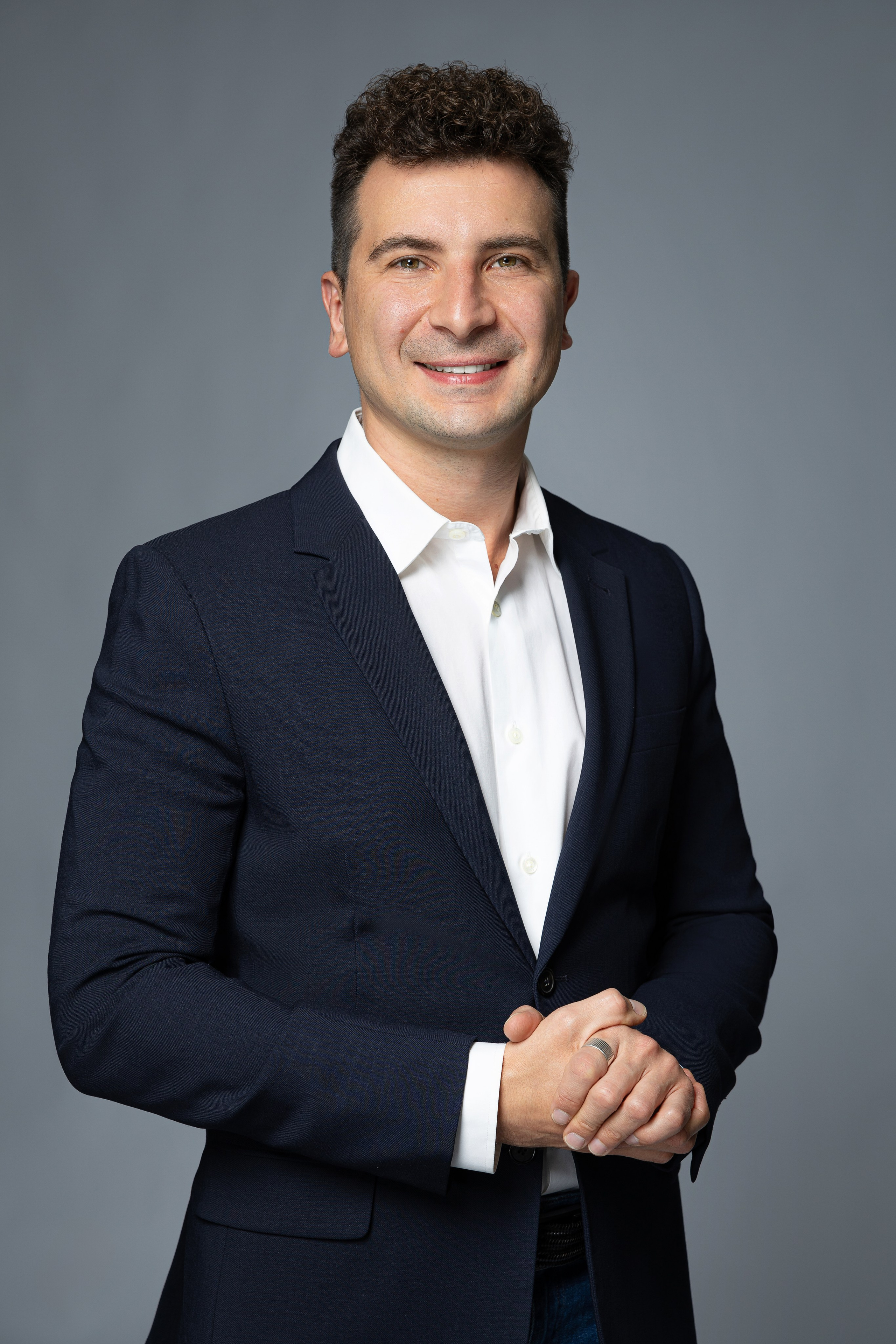 Бизнес-портрет мужчины в пиджаке и белой рубашке на однотонном фоне