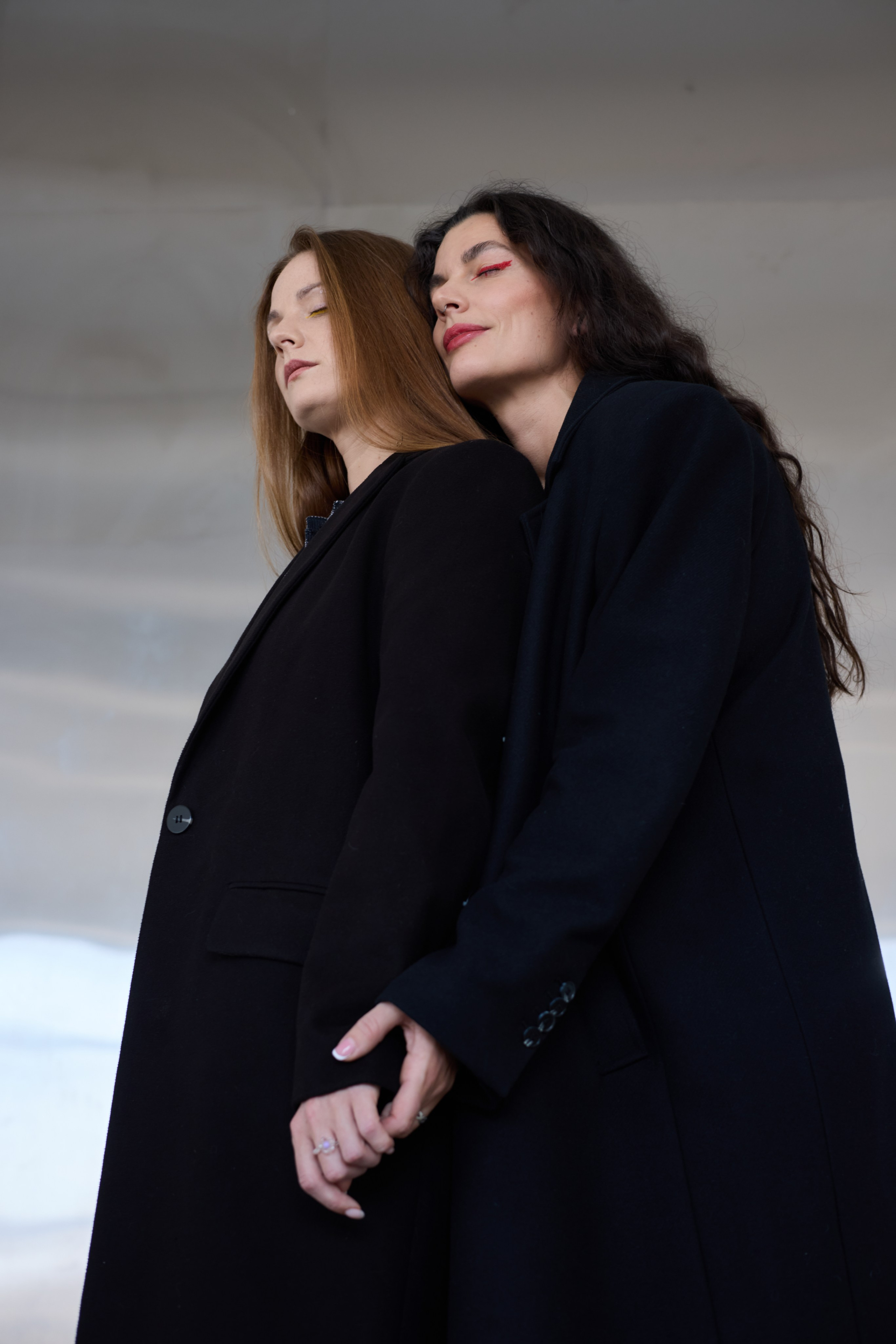 Две девушки на фоне металлической стены взявшись за руки. Виктория Брызгалова и Анна Пижонкова