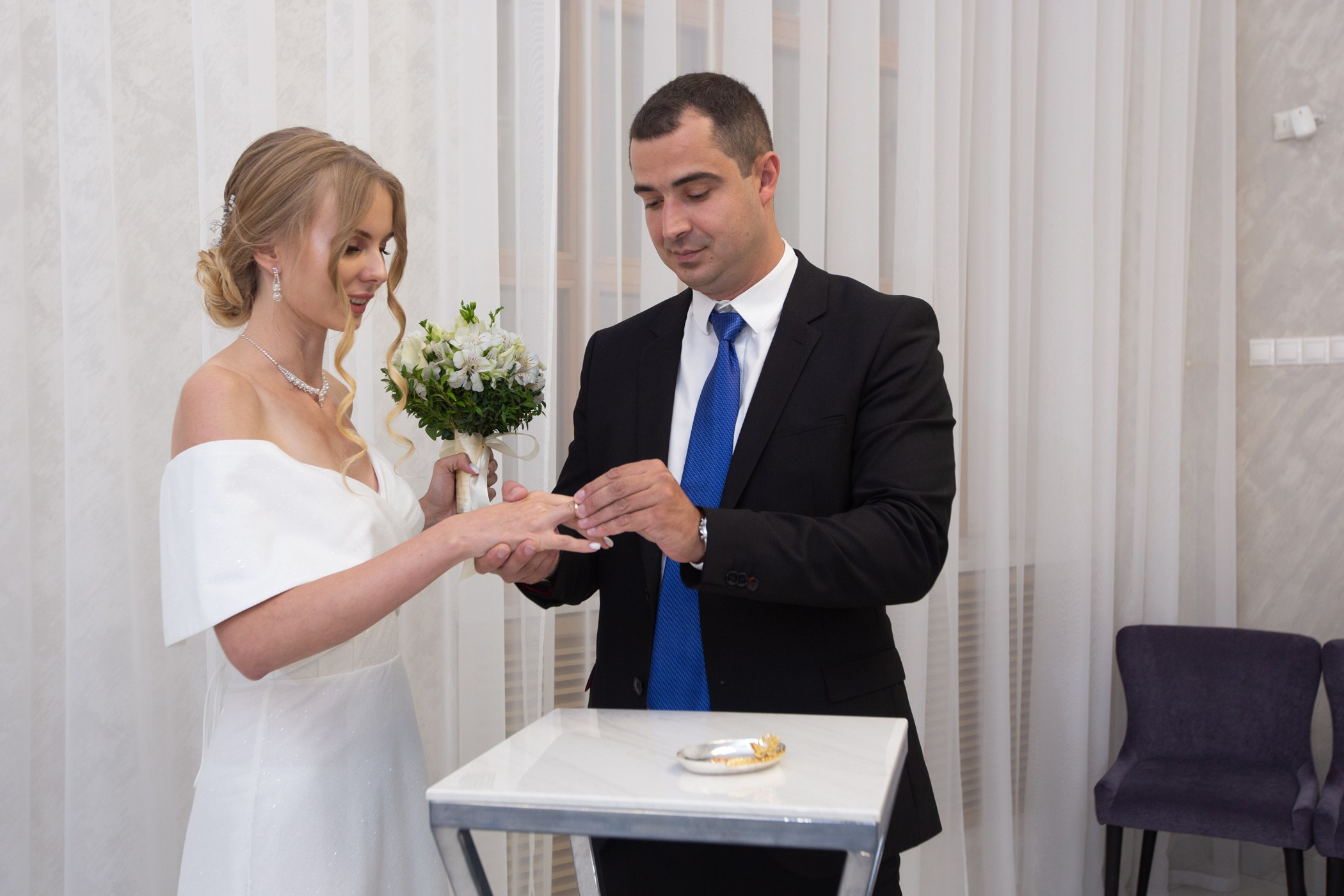 свадебная фотосессия где жених надевает обручальное кольцо невесте в кутузовском загсе