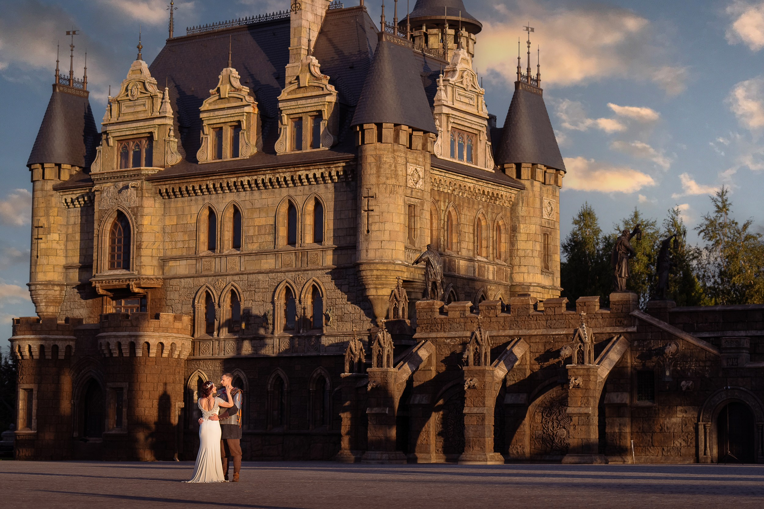 Величественный фасад замка Гарибальди на фоне закатного неба, подчеркивающий неоготические башни и богатую архитектуру.