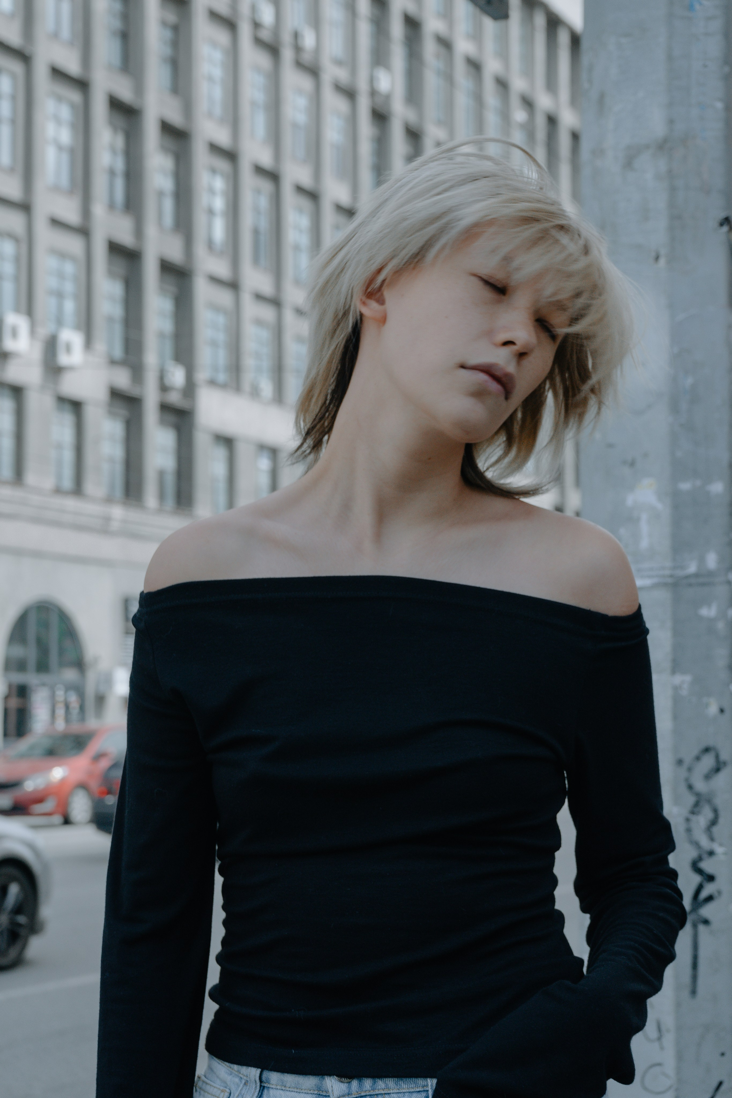 Модель позирует на фоне большого дома 