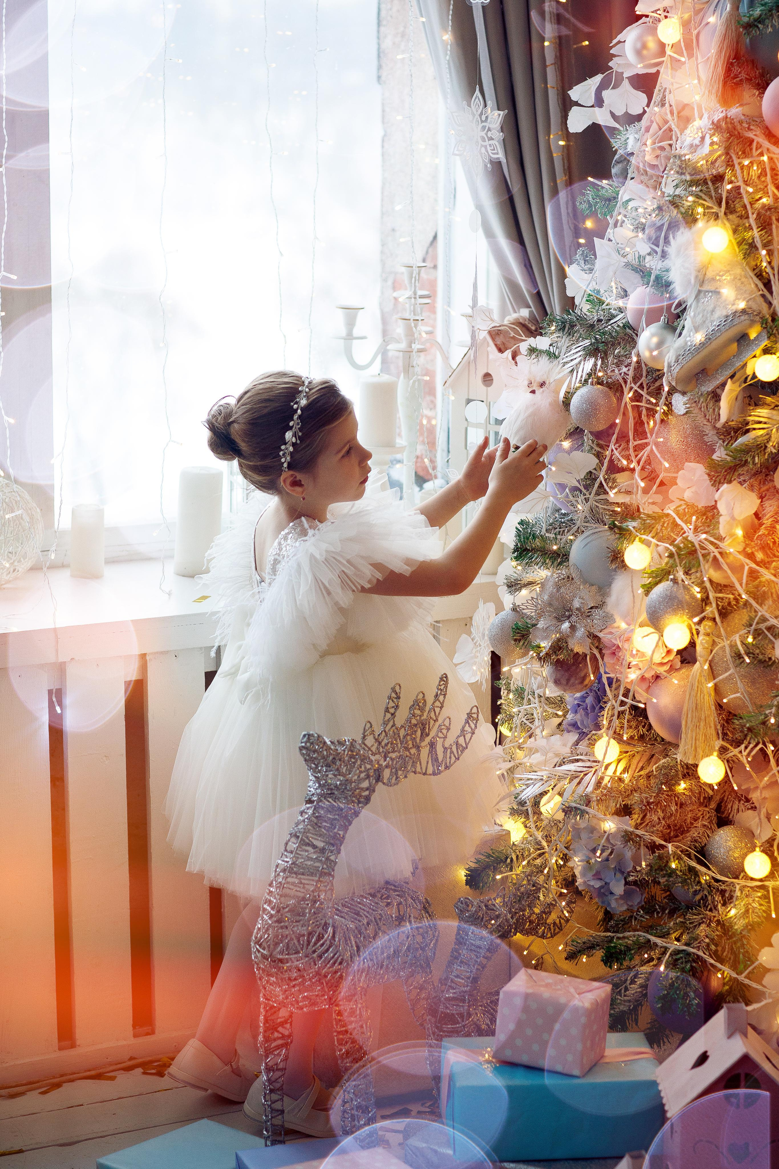 Девочка наряжает елку