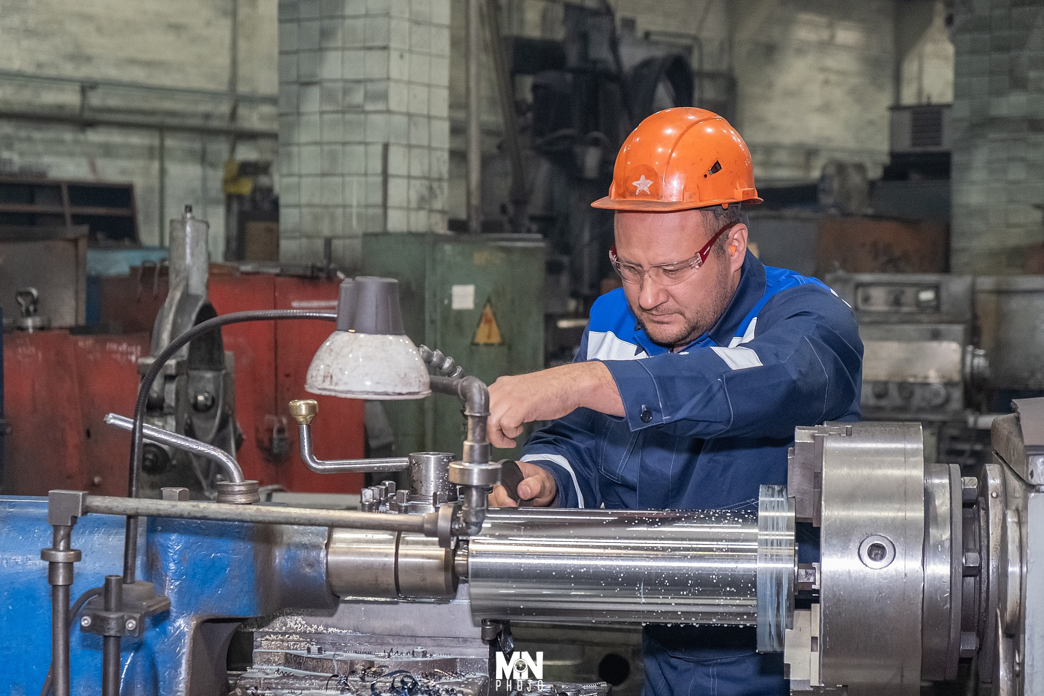 Внимательный токарь оценивает качество обработанной детали.