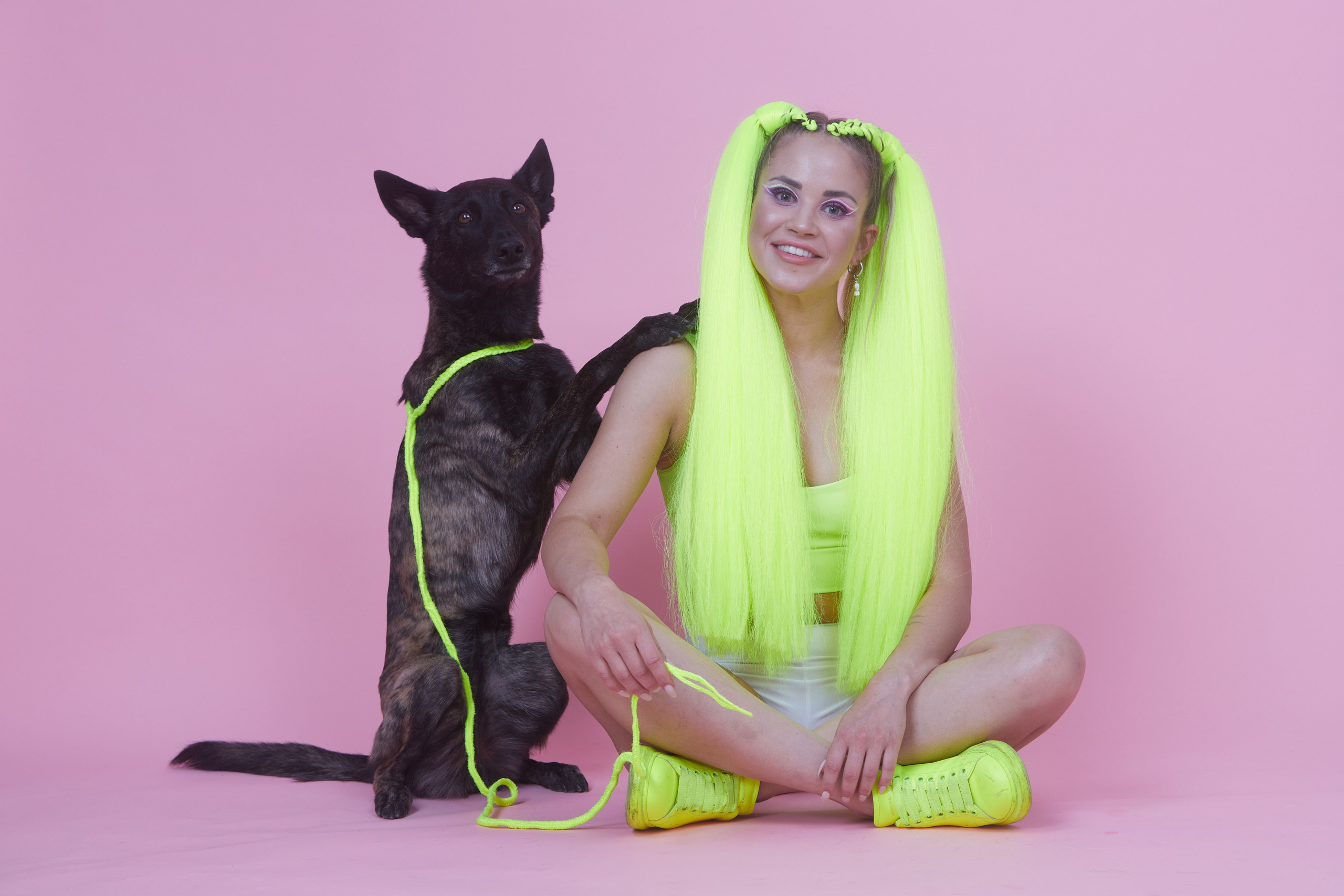 Рекламная съёмка — девушка с неоновыми жёлтыми хвостами сидит рядом с собакой.