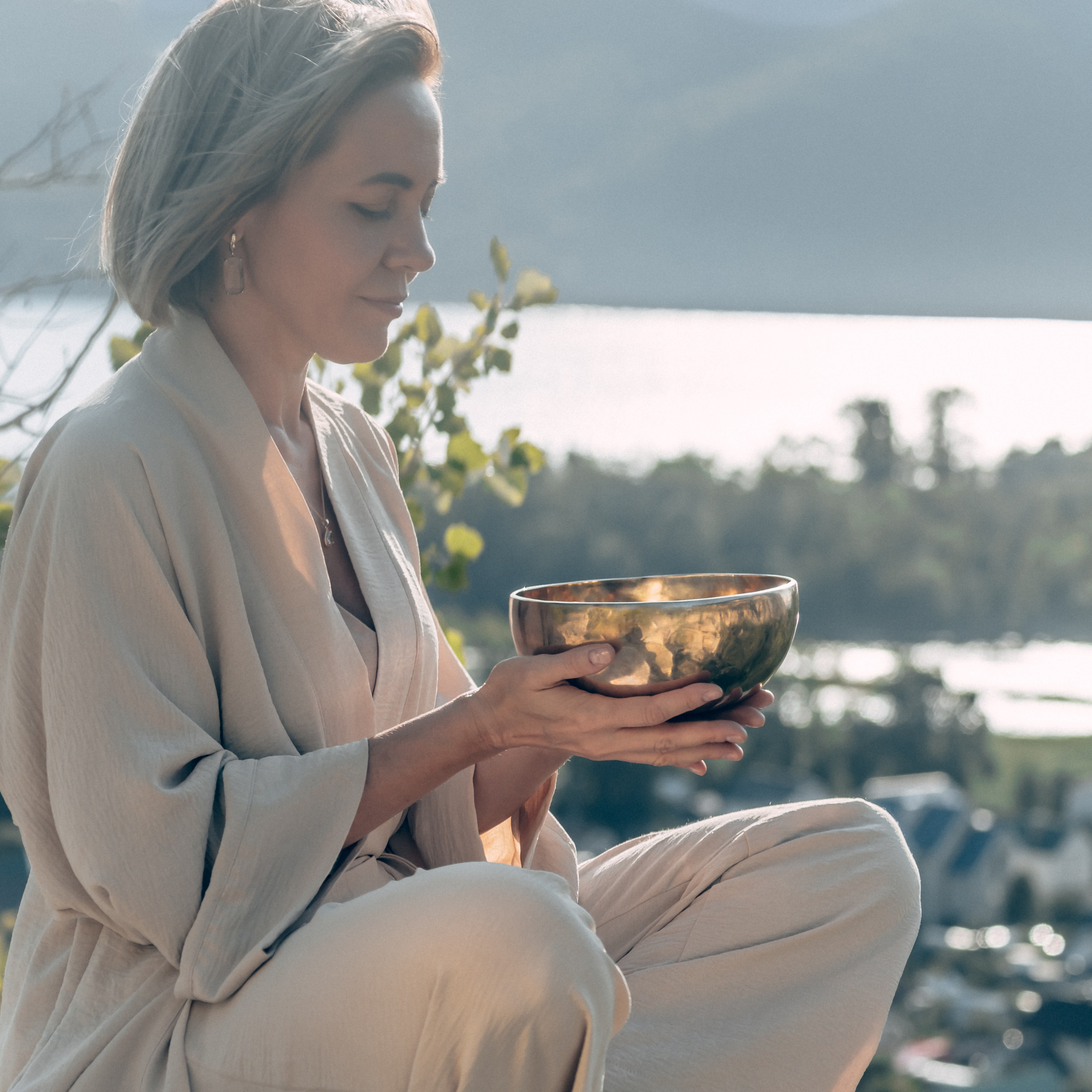 Женщина в минималистичном образе на фоне реки Волги с чашей