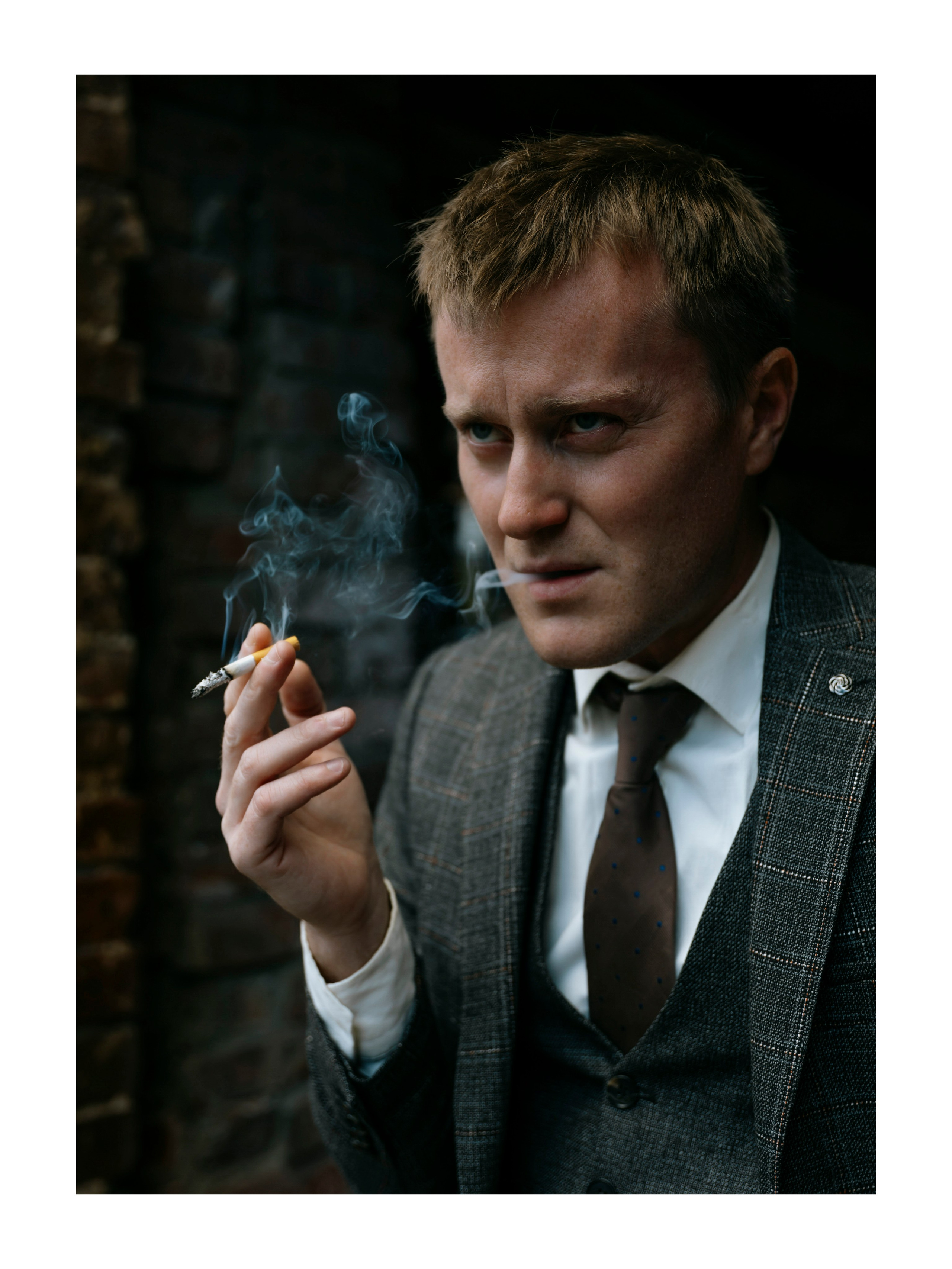 мужчина морщится и курит