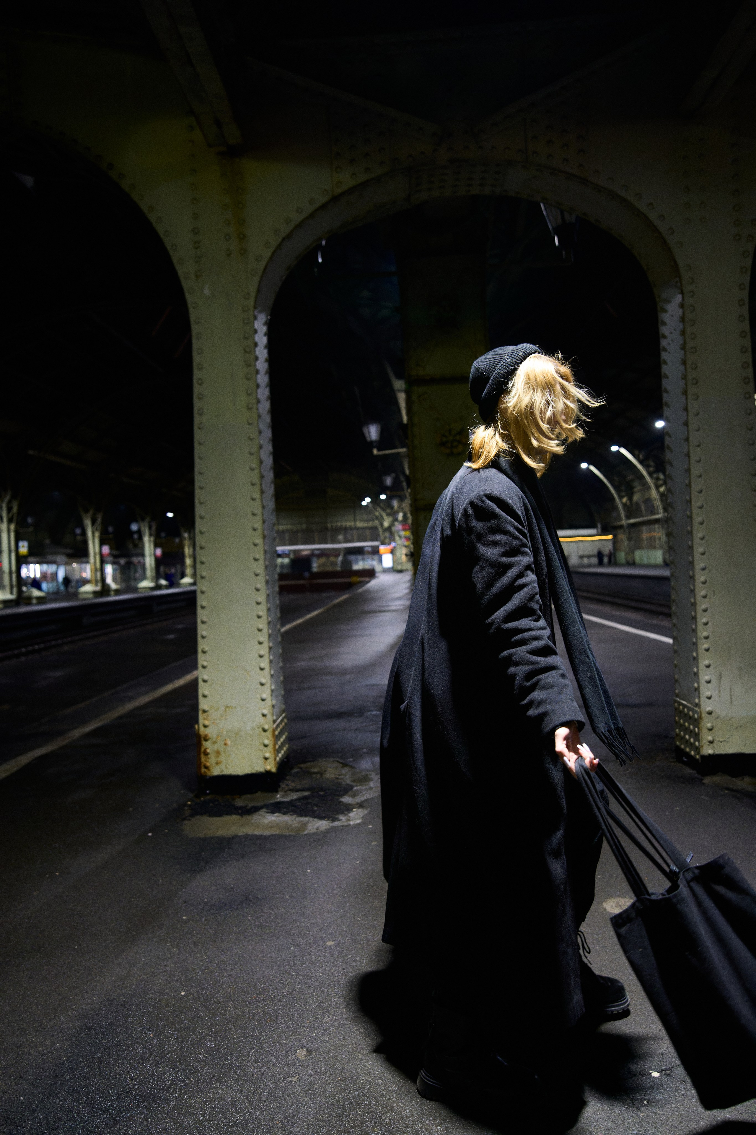 Девушка в шапке и пальто на вокзале 