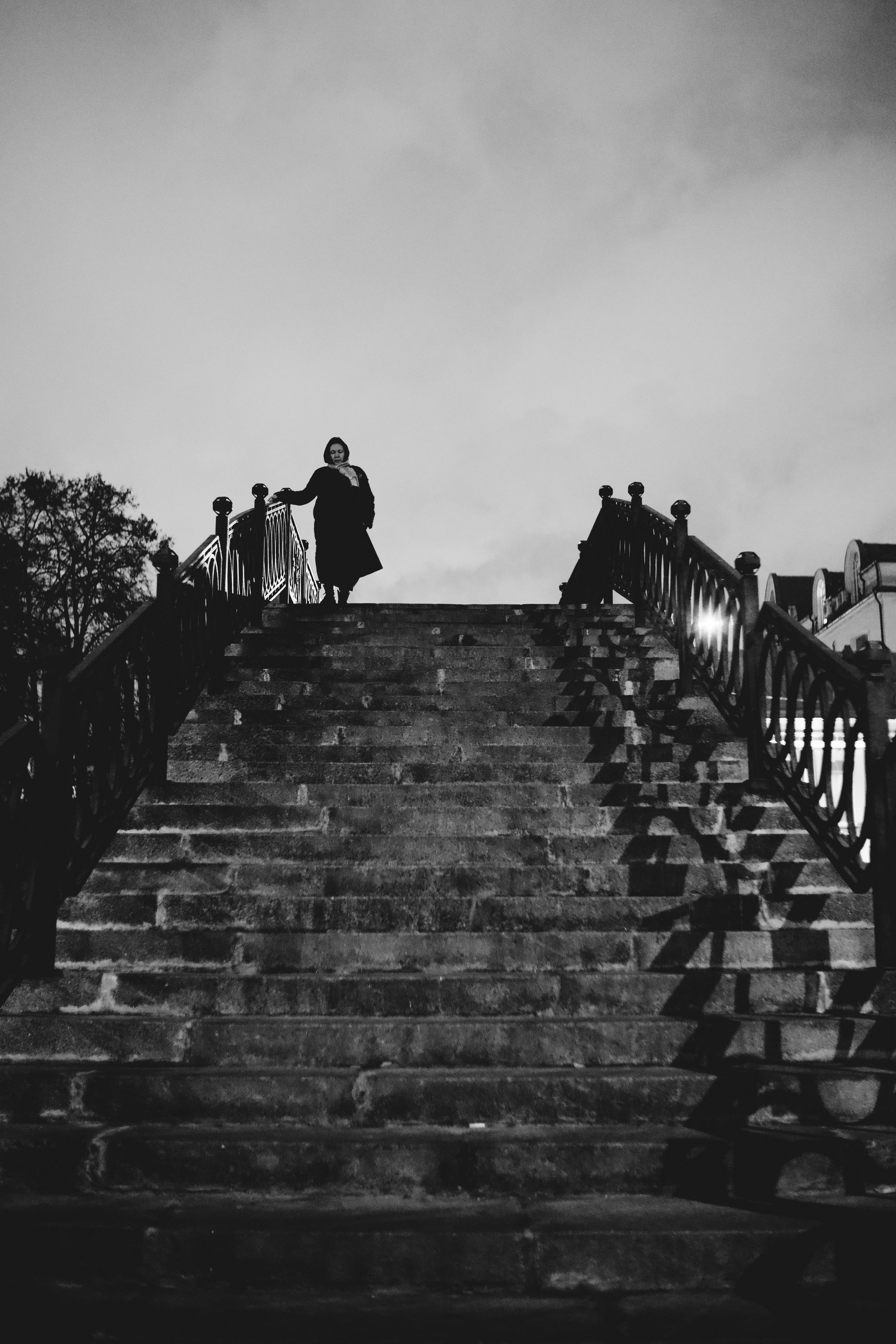 Силуэт женщины, переходящей водоотводный канал в Москве, на вершине моста