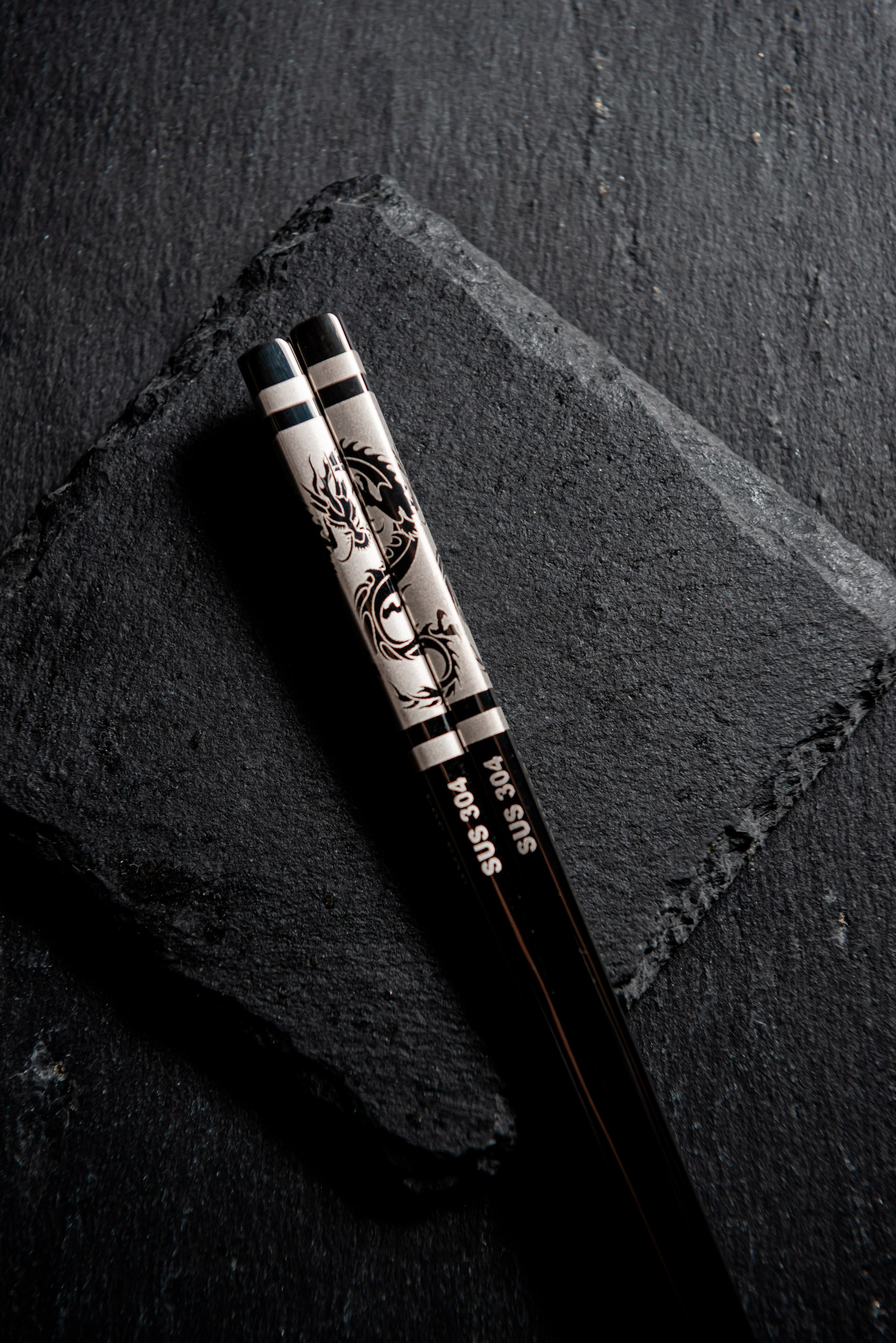 гравировка на палочках для еды из нержавейки крупным планом. гравировка в виде дракона. Фотограф для маркетплейсов в Волгограде и Волжском