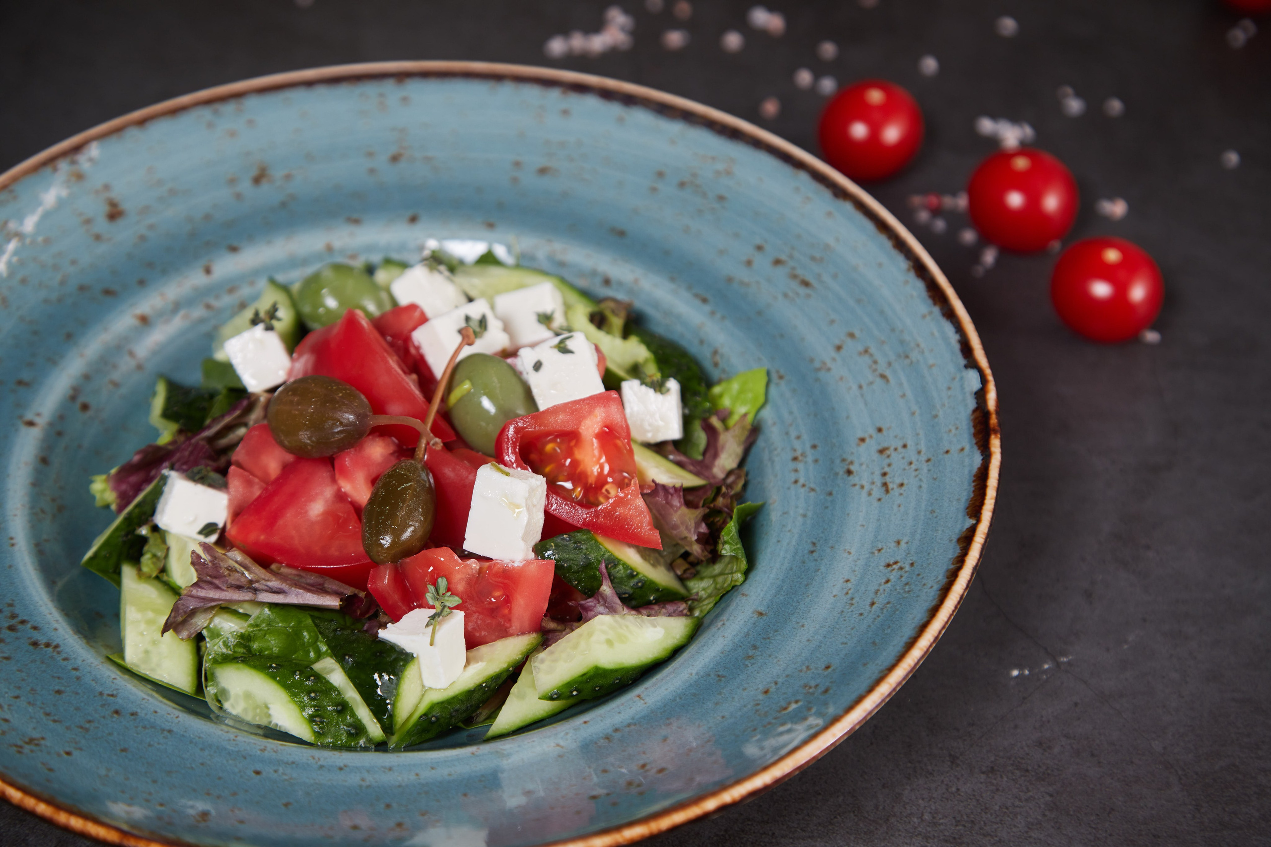 Греческий салат с помидорами, огурцами, сыром фета и зеленью.