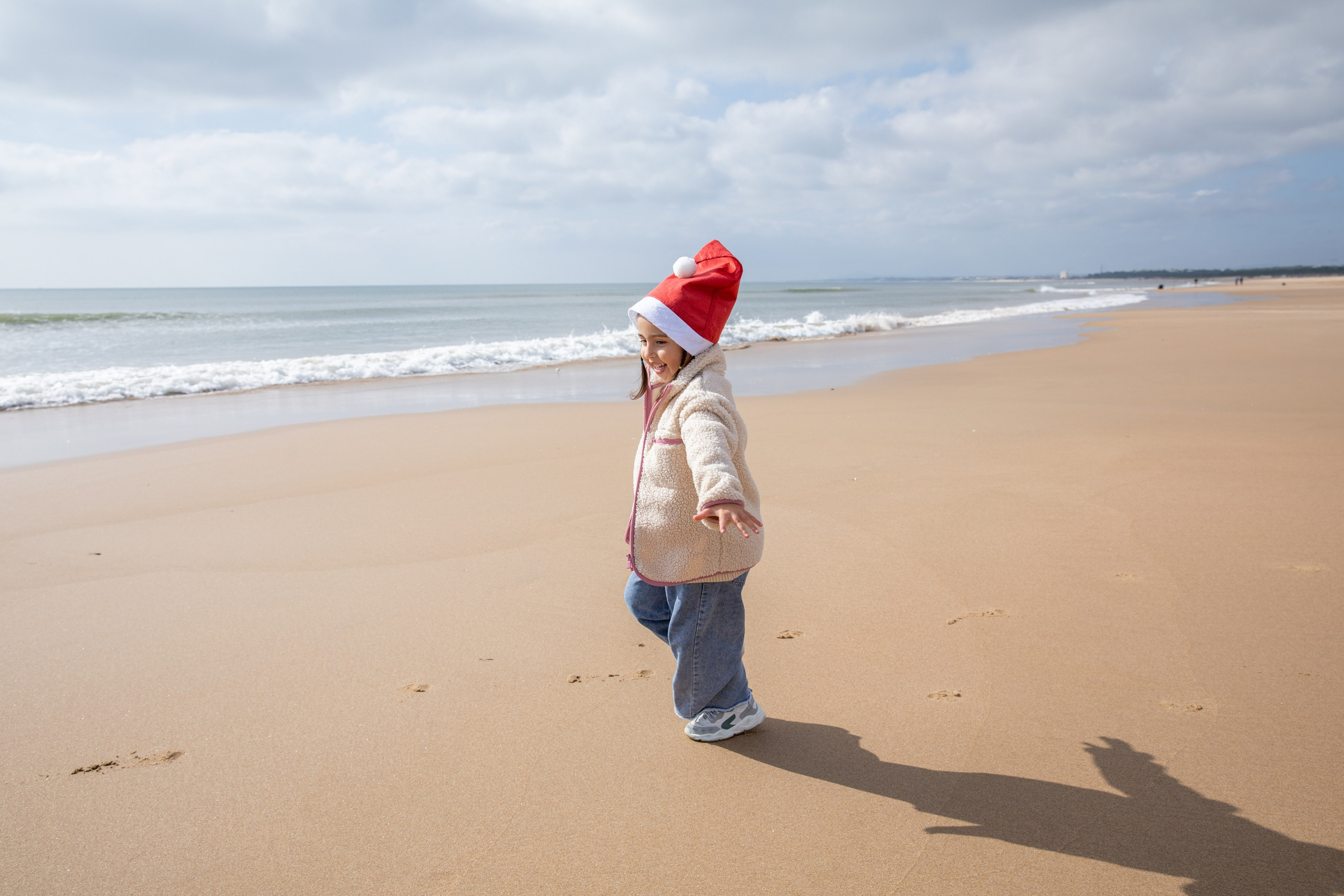 A moment of wonder, as the daughter stands by the water, mesmerized by the ocean