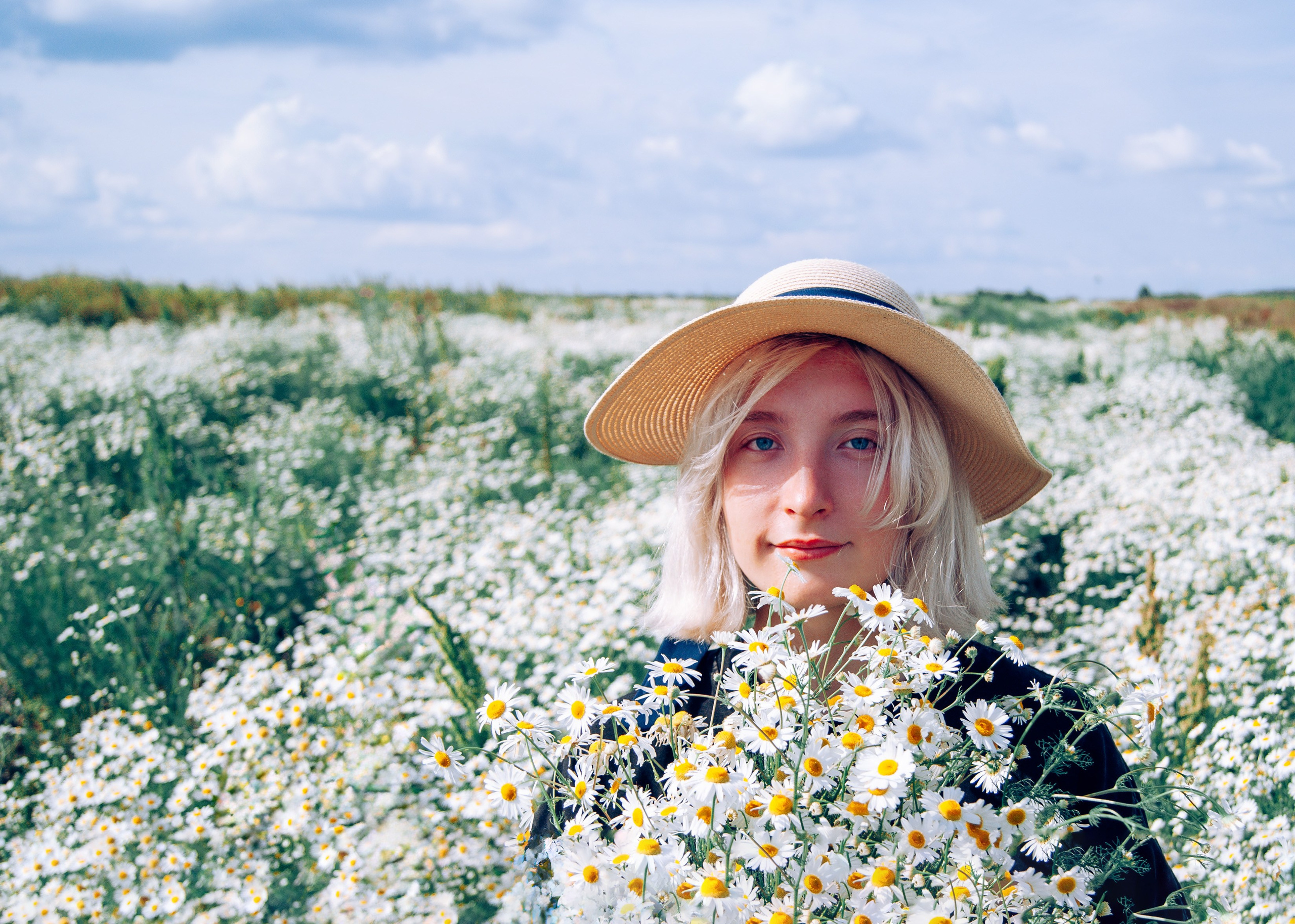 девушка в шляпе на ромашковом поле