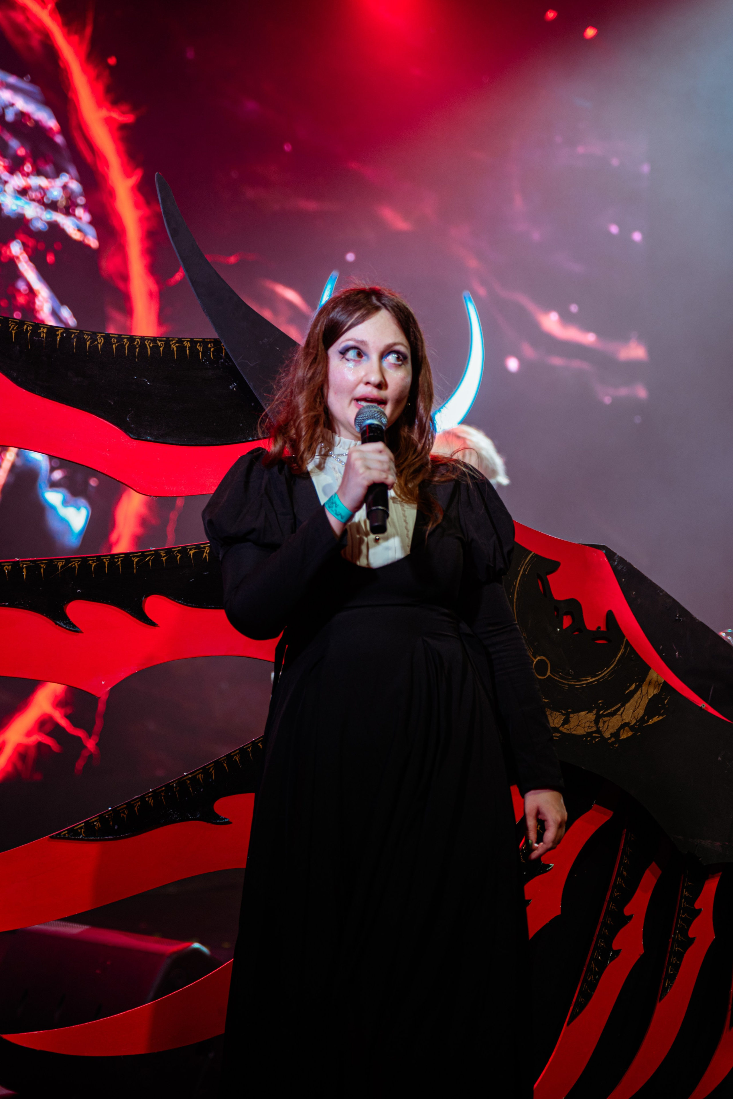 Фестиваль электронной музыки, певица с микрофоном на сцене, красный свет