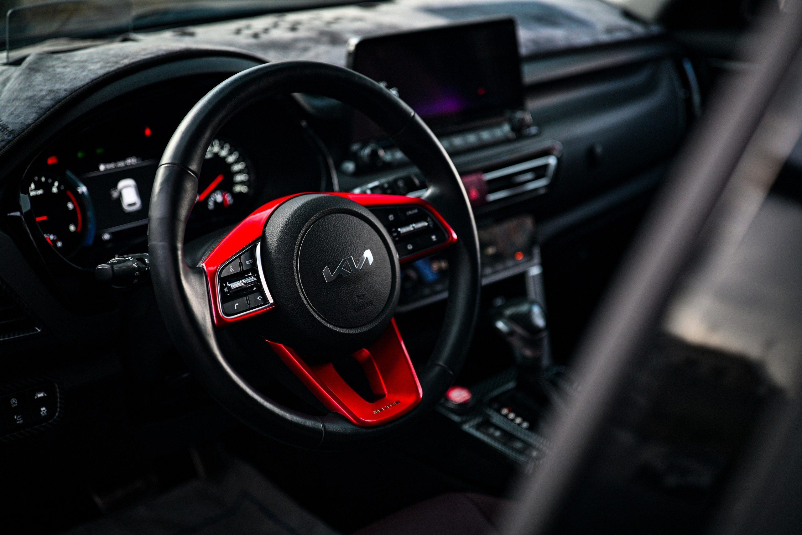 Профессиональное фото автомобиля Kia Seltos в городских джунглях Новосибирска. Съемка с нижнего ракурса на фоне размытого делового центра. Акцент на агрессивный передний бампер и хромированные элементы кроссовера. Сине-оранжевая тонировка (цветокоррекция) создает атмосферу мегаполиса. Обзор экстерьера, автомобильный стайлинг, реклама корейского автопрома