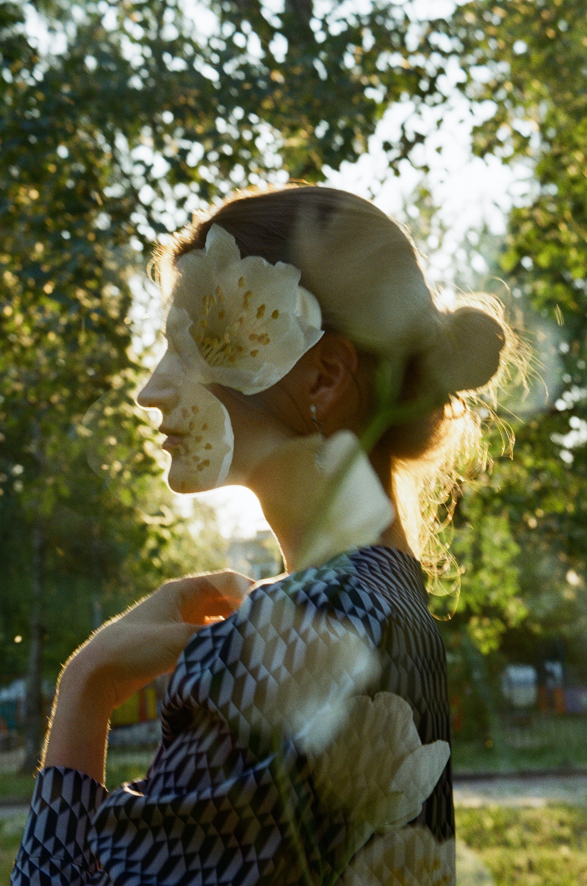 Силуэт красивой девушки в контровом солнечном свете с двойной экспозицией в белых цветах чубушника