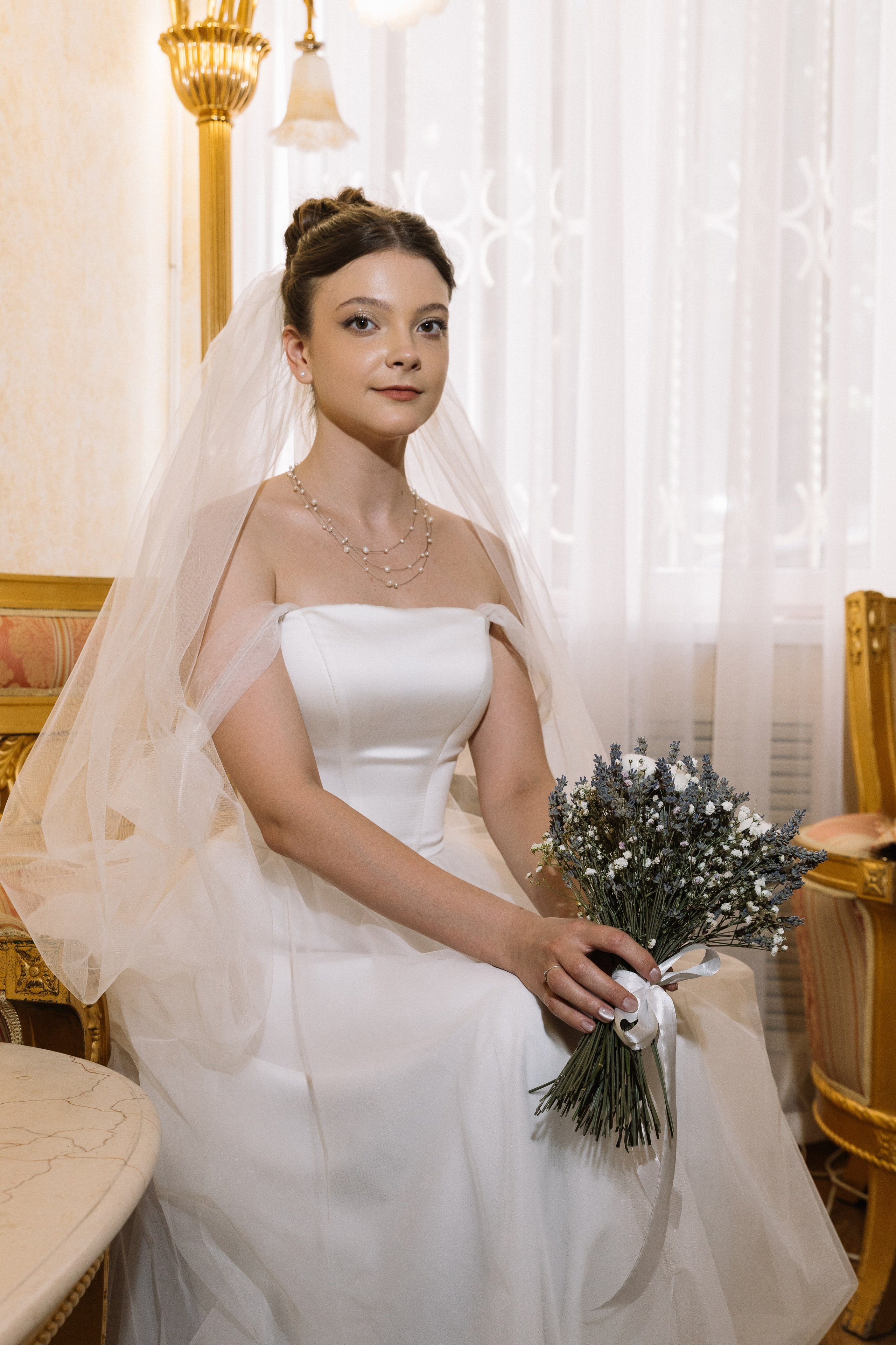 Девушка позирует в  свадебном платье, молочные тона