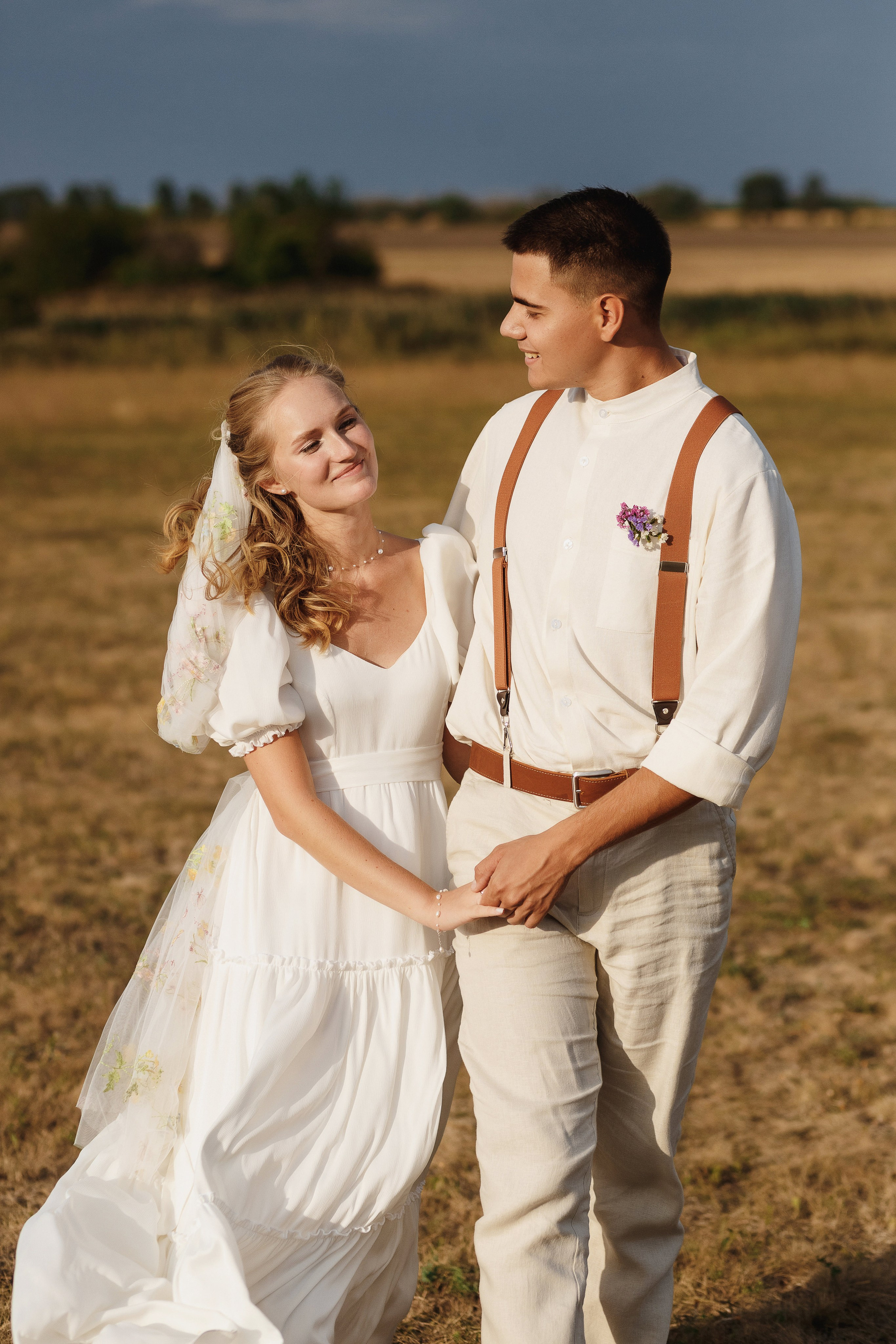 Улыбка и любовь: невеста и жених держатся за руки — свадебная фотосъёмка на природе, Таганрог.