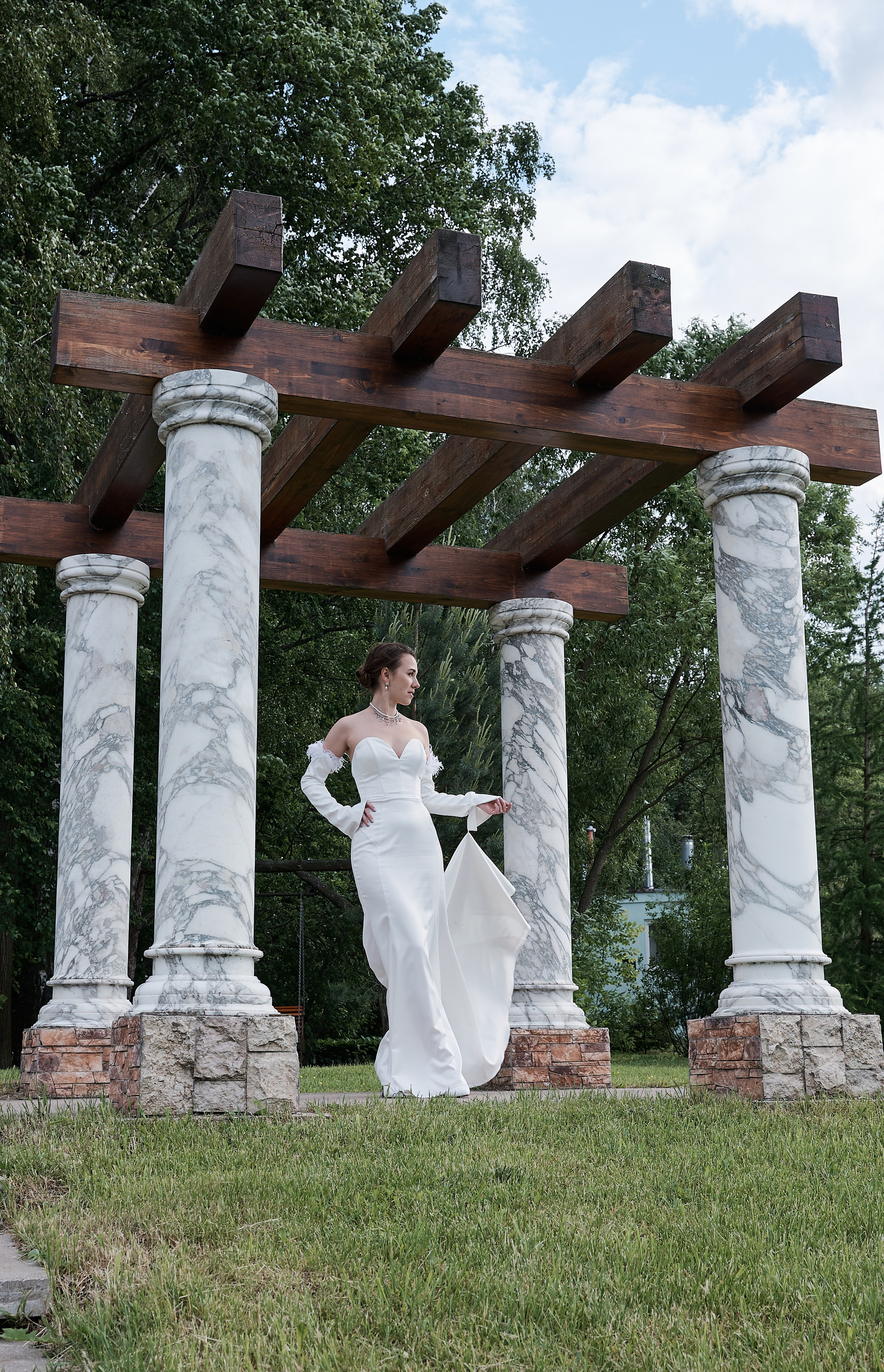 Невеста в белом платье у колоннады с голубым букетом, документальный стиль, свадебный фотограф Москва