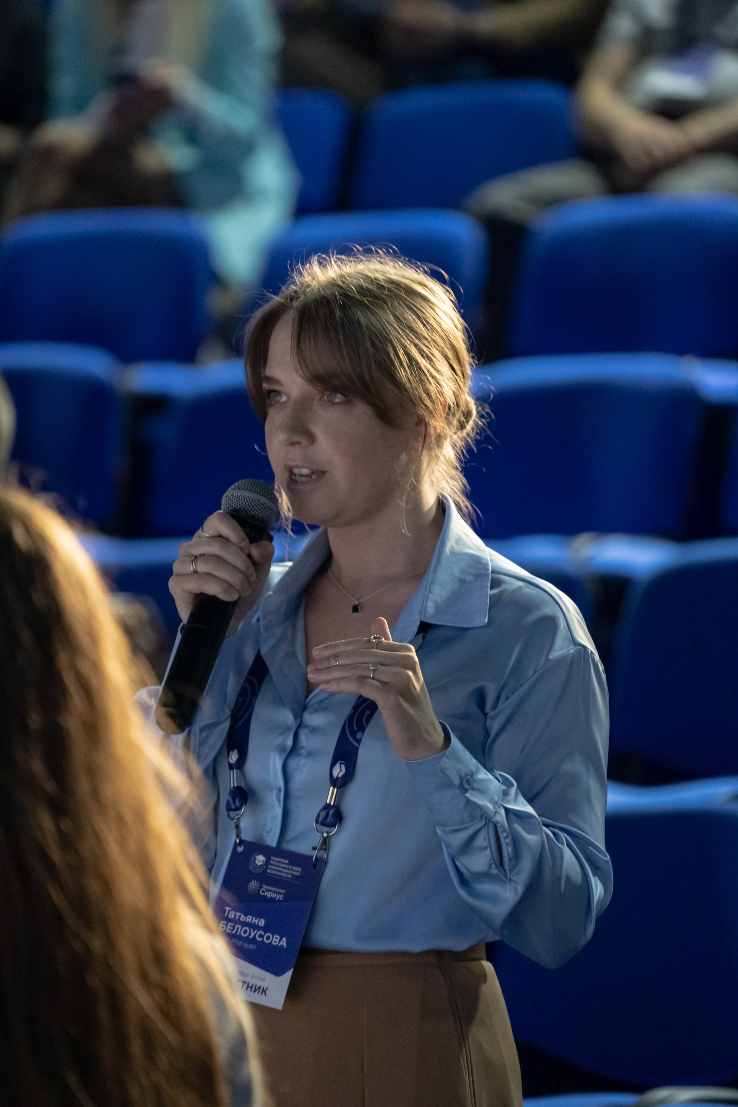 Фотография девушки с зала которая задает вопрос докладчикам