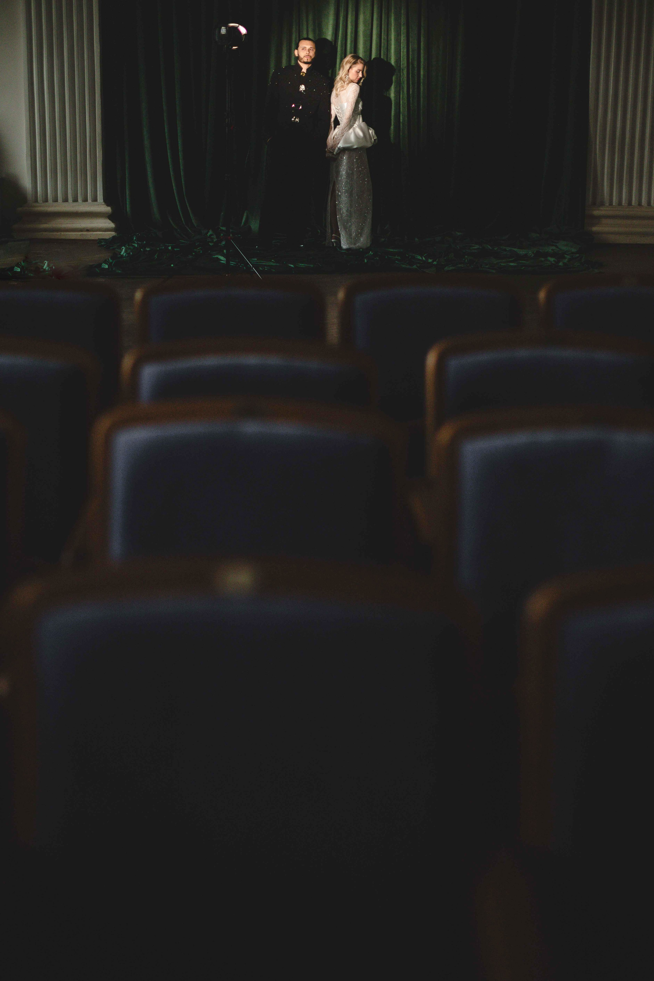 Счастливая пара позирует на свадебной фотосессии на фоне зеленой ткани в театре ,фэшн съемка ,топ 100 — свадебный фотограф Алена Межевова