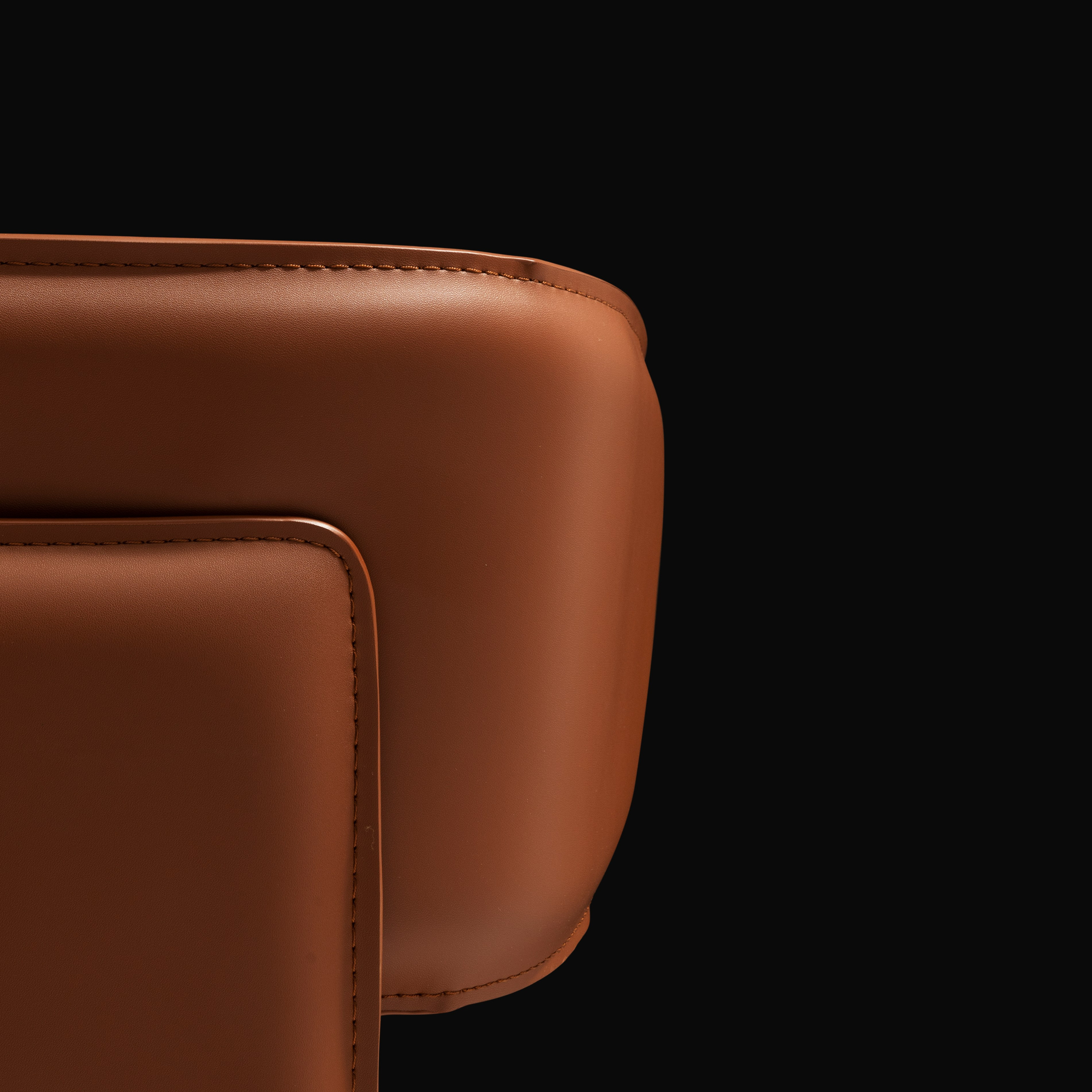 кожаный стул коричневого цвета на черном фоне 