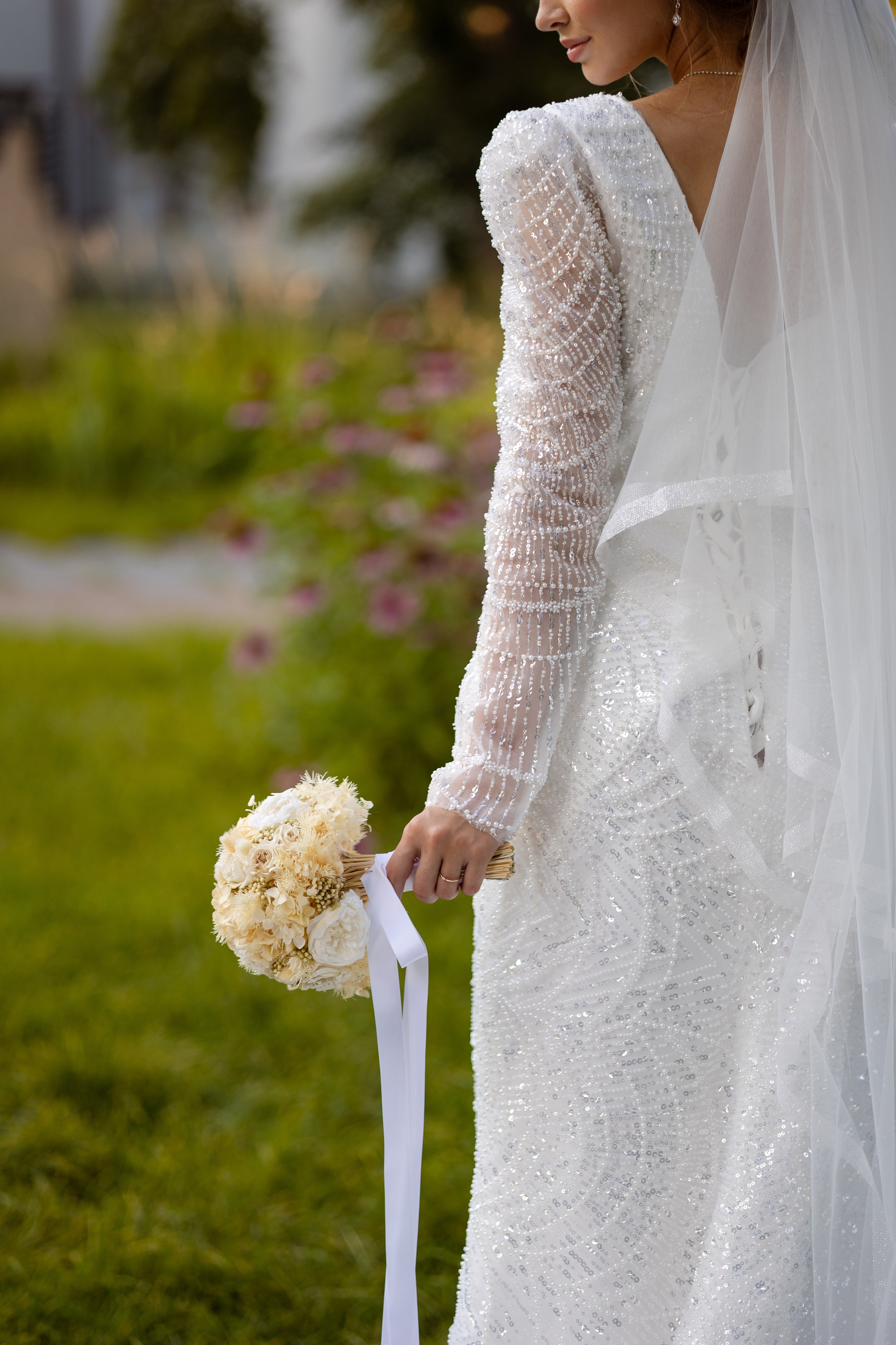 На переднем плане букет невесты в левой руке.