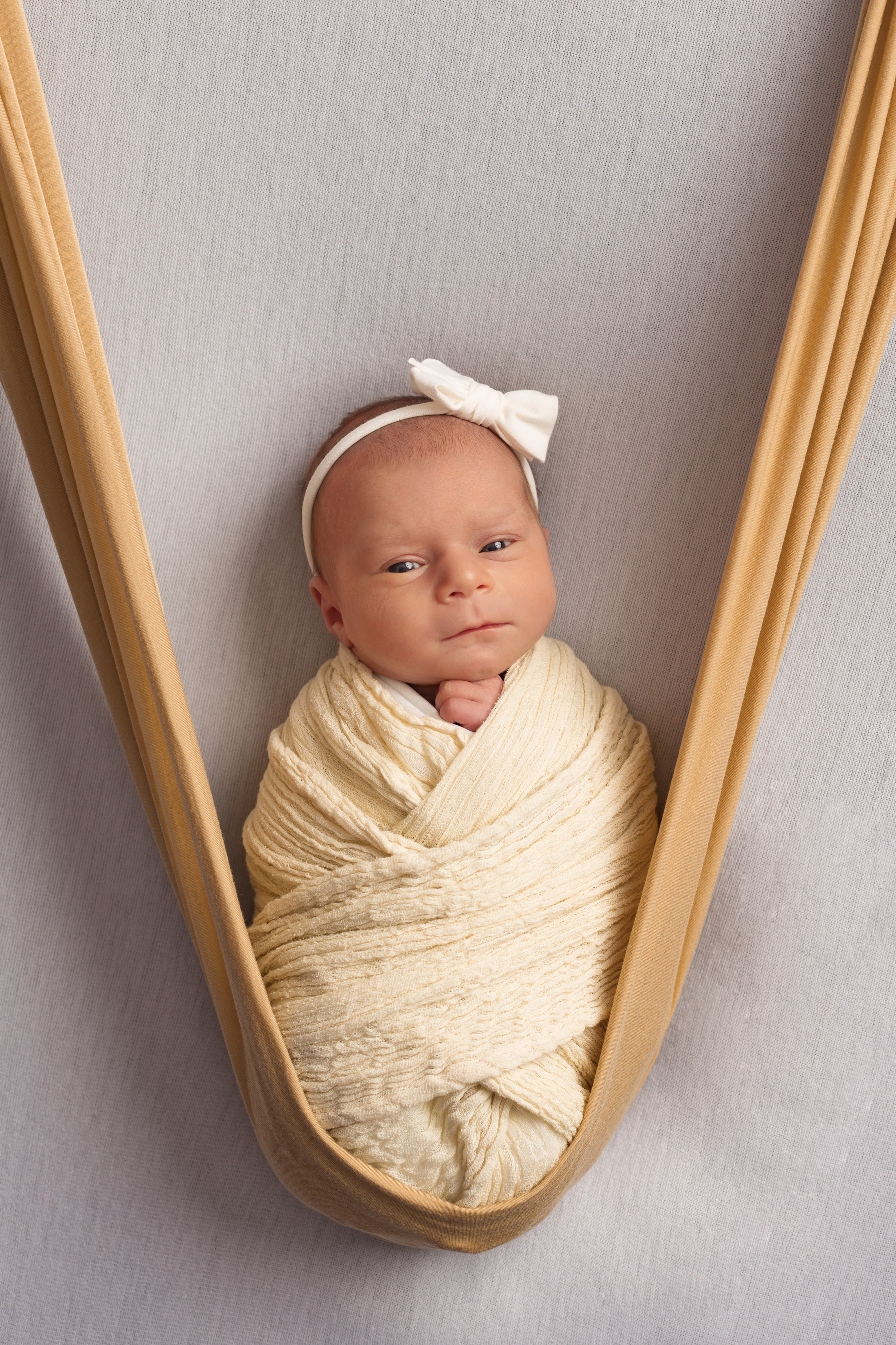 новорожденная девочка на качельках из ткани